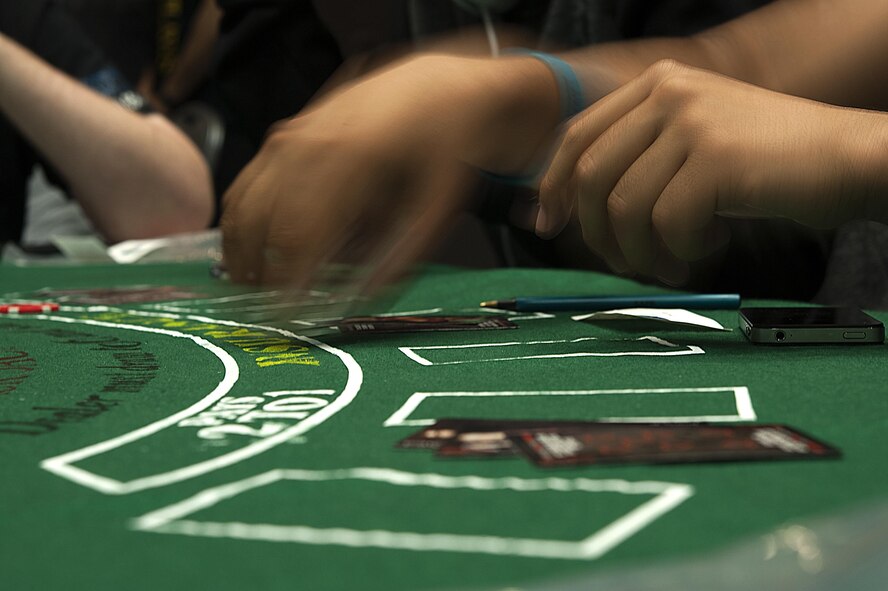 A participant places his chips down during the 4th Annual Sexual Assault Prevention and Response Guys Night Out at the Event Center on Goodfellow Air Force Base, Texas, Nov. 12, 2015. The Sexual Assault Prevention and Response program held the event to raise sexual assault awareness and build resiliency. (U.S. Air Force photo by Airman 1st Class Caelynn Ferguson/Released)