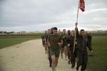 Master Sgt. Jason Annis raises the guidon in celebration as the Marines finish 240 laps around the Semper Fit track Nov. 10 on Marine Corps Air Station Futenma, Okinawa, Japan. The Marines ran the laps to celebrate the 240th Marine Corps Birthday. It took the Marines over seven hours to finish. Annis is the communications chief for MCAS Futenma S-6, Communications, Marine Corps Installations Pacific.