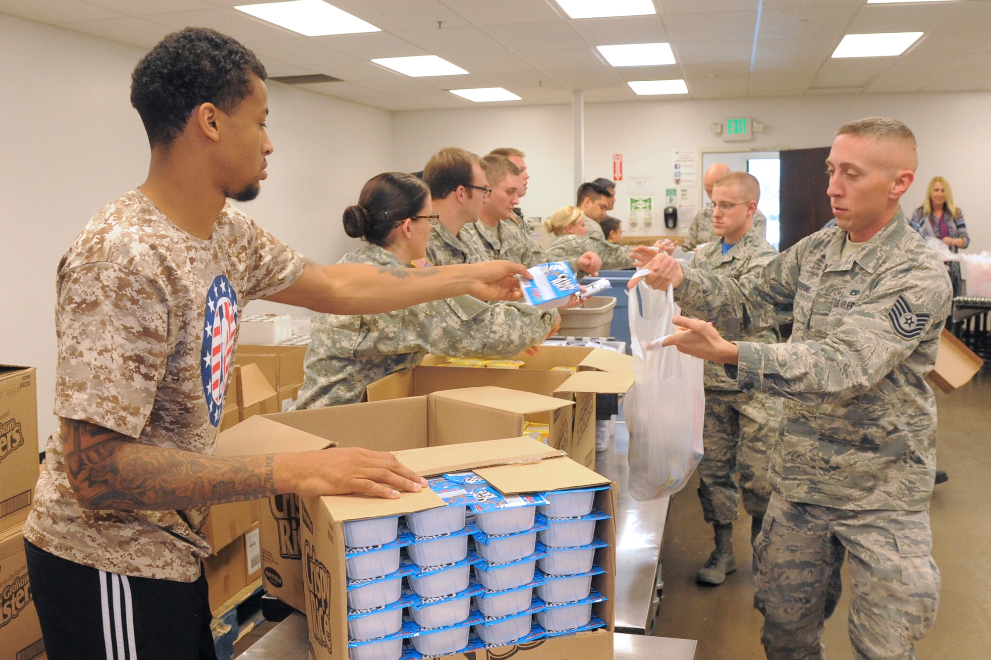 Utah Jazz player Trey Burke and Tech. Sgt. Ross Robbins, 419th Maintenance Squadron, collect food items for distribution to local schoolchildren in Salt Lake City Nov. 6. (U.S. Air Force photo/Todd Cromar) 