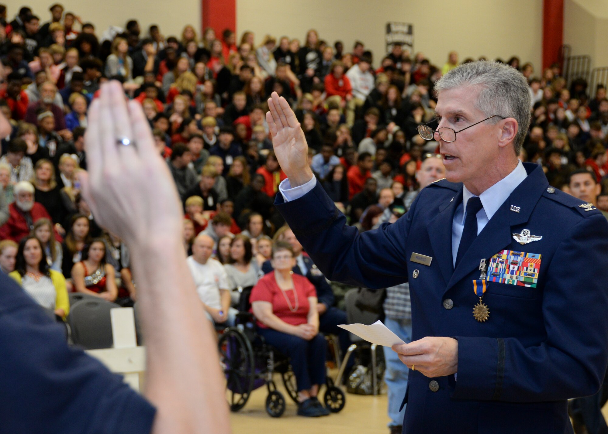 Col. Trey Morriss, 596th Bomb Squadron electronic warfare officer during Operation Senior Surprise, administers the Oath of Enlistment to four Parkway High School students waiting to join the military during an annual Veterans Day Tattoo Ceremony at Parkway High School in Bossier City, La., Nov. 11, 2015. Operation Senior Surprise was a clandestine mission that helped kick off Operation Desert Storm. Before leaving for Basic Military Training, every service member must promise to adhere to the Oath of Enlistment. (U.S. Air Force photo/Senior Airman Amanda Morris)  