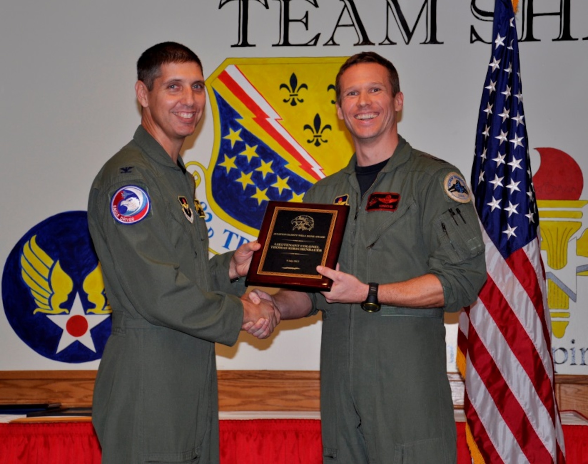 Col. Gregory Keeton (left), 80th Flying Training Wing commander, presents Lt. Col. Thomas Kirschenbauer, 88th Flying Training Squadron instructor pilot, the prestigious Aviation Safety Well Done Award during a warrior call Nov. 13, 2015 at Sheppard Air Force Base, Texas.  Kirschenbauer, a German Air Force instructor pilot with the Euro-NATO Joint Jet Pilot Training Program, used innovative communication methods and superb flying skills when an in-flight emergency bird strike threatened his T-38 Talon sortie. He is credited with saving two lives and the eight million dollar aircraft. (U.S. Air Force Photo/Debi Smith)