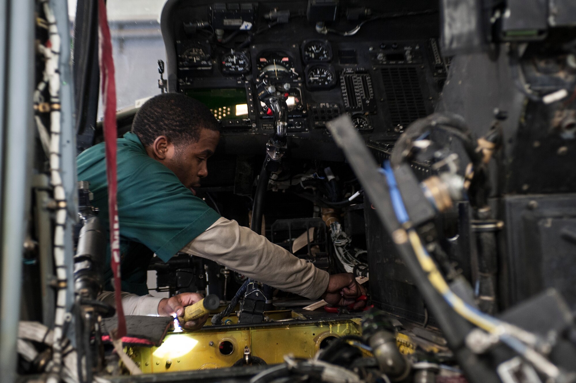 Staff Sgt. Warrell Rickets, 823rd Maintenance Squadron specialist, prepares to remove an adel clamp on an HH-60G Pave Hawk at Nellis Air Force Base, Nev., Nov. 10, 2015. The adel clamp holds wire bundles together, and Rickets needed to remove the clamp to install a washer on a different component of the aircraft. (U.S. Air Force photo by Staff Sgt. Siuta B. Ika)