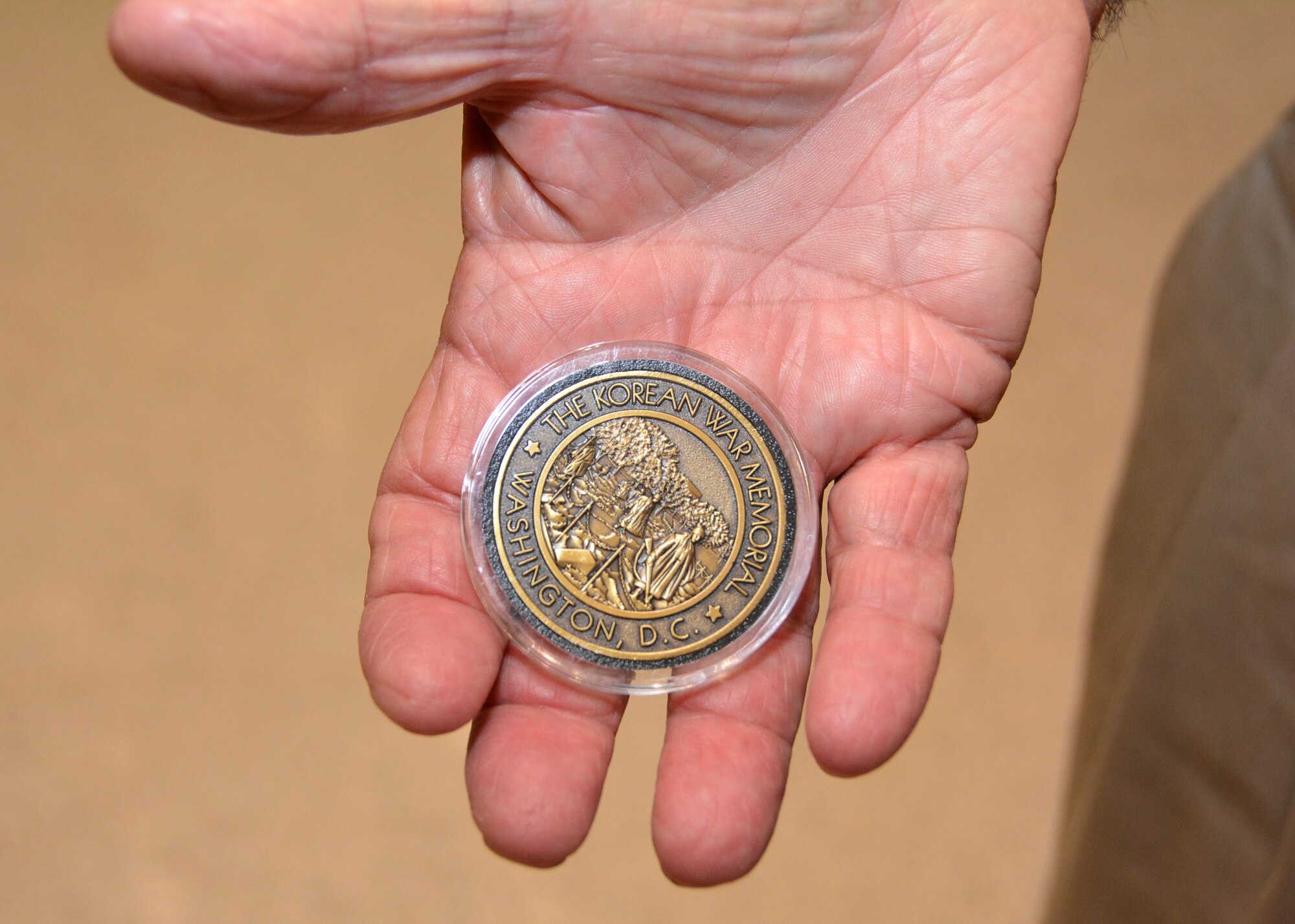Jim Whitsett, 87, extends his hand to display his memorial coin presented to him during the Honor Flight reception ceremony Sept. 15, 2015, at the Hudiburg Center in Midwest City, Okla. Whitsett, a Tulsa native, served in the U.S. Army during the Korean War. (U.S. Air Force photo by Tech. Sgt. Lauren Gleason)
