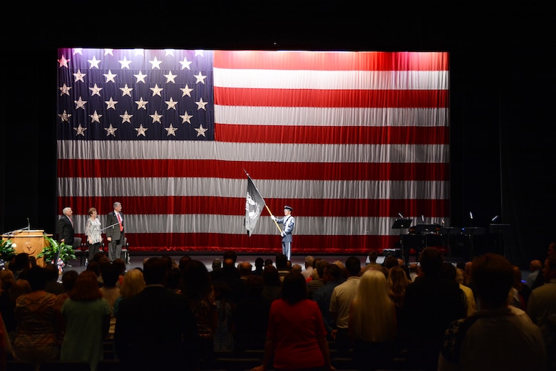 Veterans and guests stand and face the flag to recognize the sacrifices made by POW/
MIA servicemembers during the Oklahoma Honor Flight reception Sept. 15, 2015, at the
Hudiburg Center in Midwest City, Okla. 81 Oklahoma veterans flew to D.C. the following day to visit memorials built in their honor as part of the Oklahoma Honor Flight Program. (U.S. Air Force photo by Tech. Sgt. Lauren Gleason)
