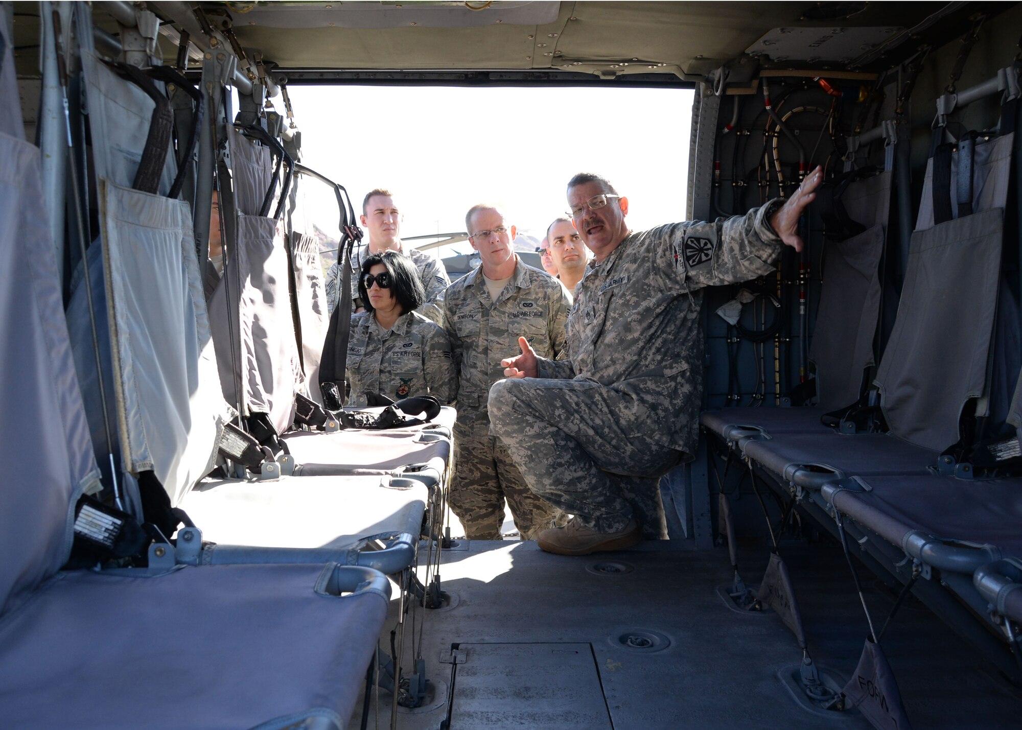 Army Staff Sgt. Tym Larson (right), Det. 1 Charlie Co. 5-159 Medevac Unit Noncommissioned officer-in-charge, points out various features of a UH-60 Black Hawk helicopter Nov. 8 to firefighters from the 944th Civil Engineer Squadron fire flight. CES firefighters coordinated the visit with Soldiers with the Arizona Aviation Support Facility. During the visit, CES firefighters received a briefing on the UH-60 and a hands-on tour of the helicopter. (U.S. Air Force photo by Staff Sgt. Nestor Cruz)