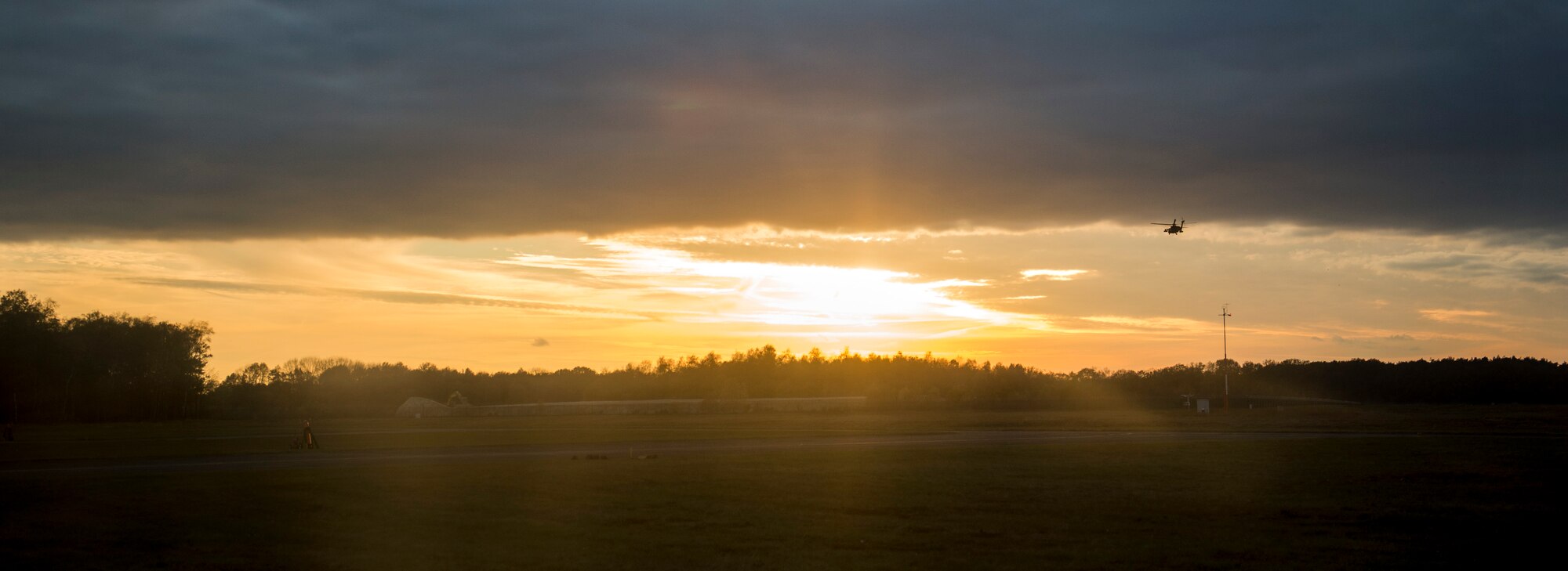 A U.S. Army UH-60 Black Hawk helicopter, assigned to the 1st Battalion 214th Aviation Regiment, flies into the sunset over Kleine Brogel Air Base, Belgium, Nov. 12, 2015. The helicopter carried Spangdahlem Airmen to and from Kleine Brogel Air Base to participate in the training. (U.S. Air Force photo by Senior Airman Rusty Frank/Released)