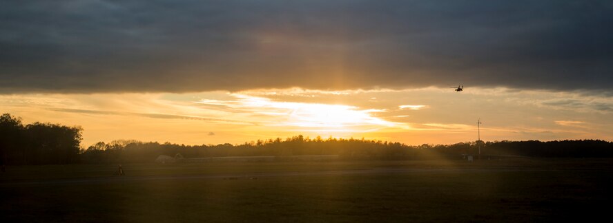 A U.S. Army UH-60 Black Hawk helicopter, assigned to the 1st Battalion 214th Aviation Regiment, flies into the sunset over Kleine Brogel Air Base, Belgium, Nov. 12, 2015. The helicopter carried Spangdahlem Airmen to and from Kleine Brogel Air Base to participate in the training. (U.S. Air Force photo by Senior Airman Rusty Frank/Released)