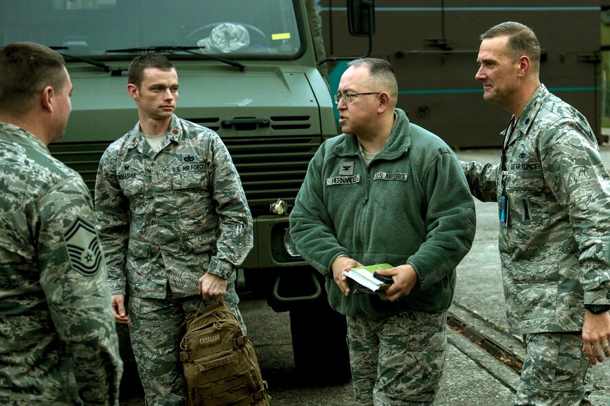 U.S. Air Force Lt. Col. Kenneth Benton, 701st Munitions Support Squadron commander, gestures to U.S. Air Force Col. Drysdale Hernandez, 52nd Mission Support Group commander, on the flight line at Kleine Brogel Air Base, Belgium, Nov. 12, 2015. Hernandez and other Airmen from Spangdahlem trained with members of the 701st MUNSS and Belgian air force.  (U.S. Air Force photo illustration by Senior Airman Rusty Frank/Released)