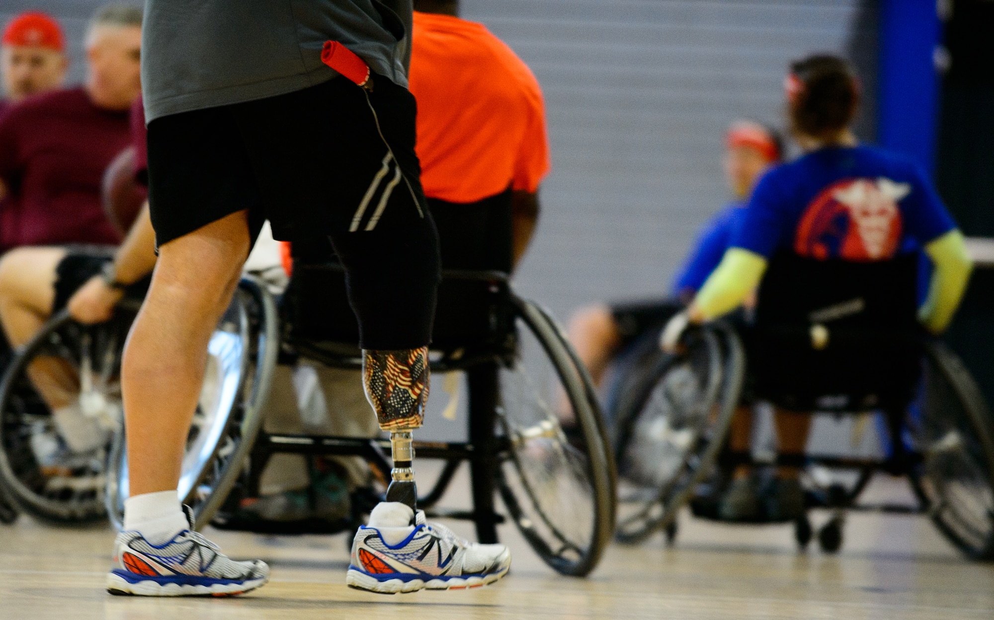 Anthony Parry, Wounded Transition Battalion adaptive sport coordinator, walks beside Airmen playing wheelchair basketball Nov. 13, 2015, at Ramstein Air Base, Germany. The WTB hosted the game to spread awareness and build camaraderie between local units. (U.S. Air Force photo/Staff Sgt. Armando A. Schwier-Morales)
