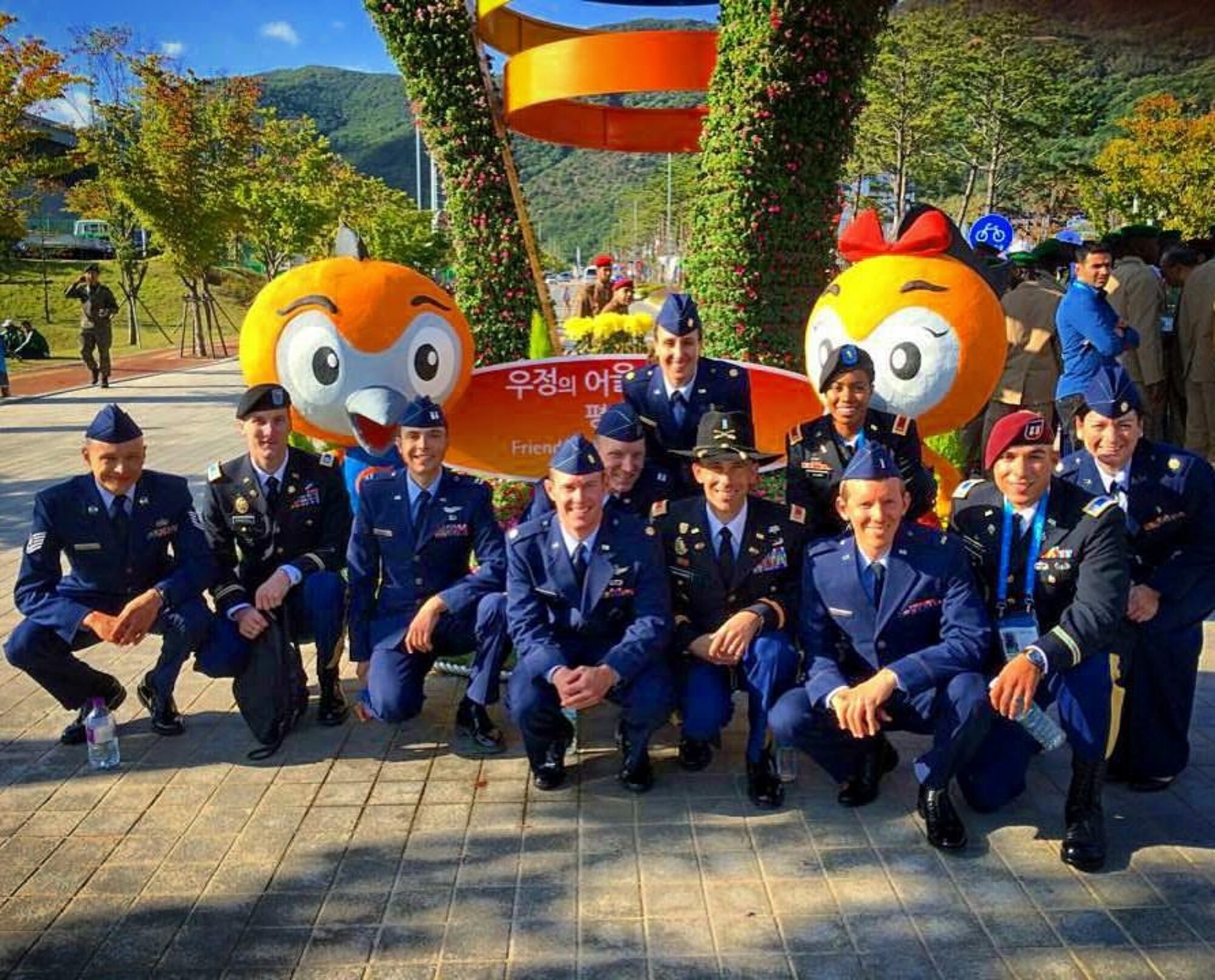 MUNGYEONG, SOUTH KOREA – Maj. Ian Holt, center, and teammates on the U.S. Armed Forces cycling team in front of the mascots of the sixth Conseil International du Sport Militaire military sports world championships held in Mungyeong, South Korea Oct. 2-11, 2015. Seven of the 11 riders on the men’s and women’s teams represented the Air Force.