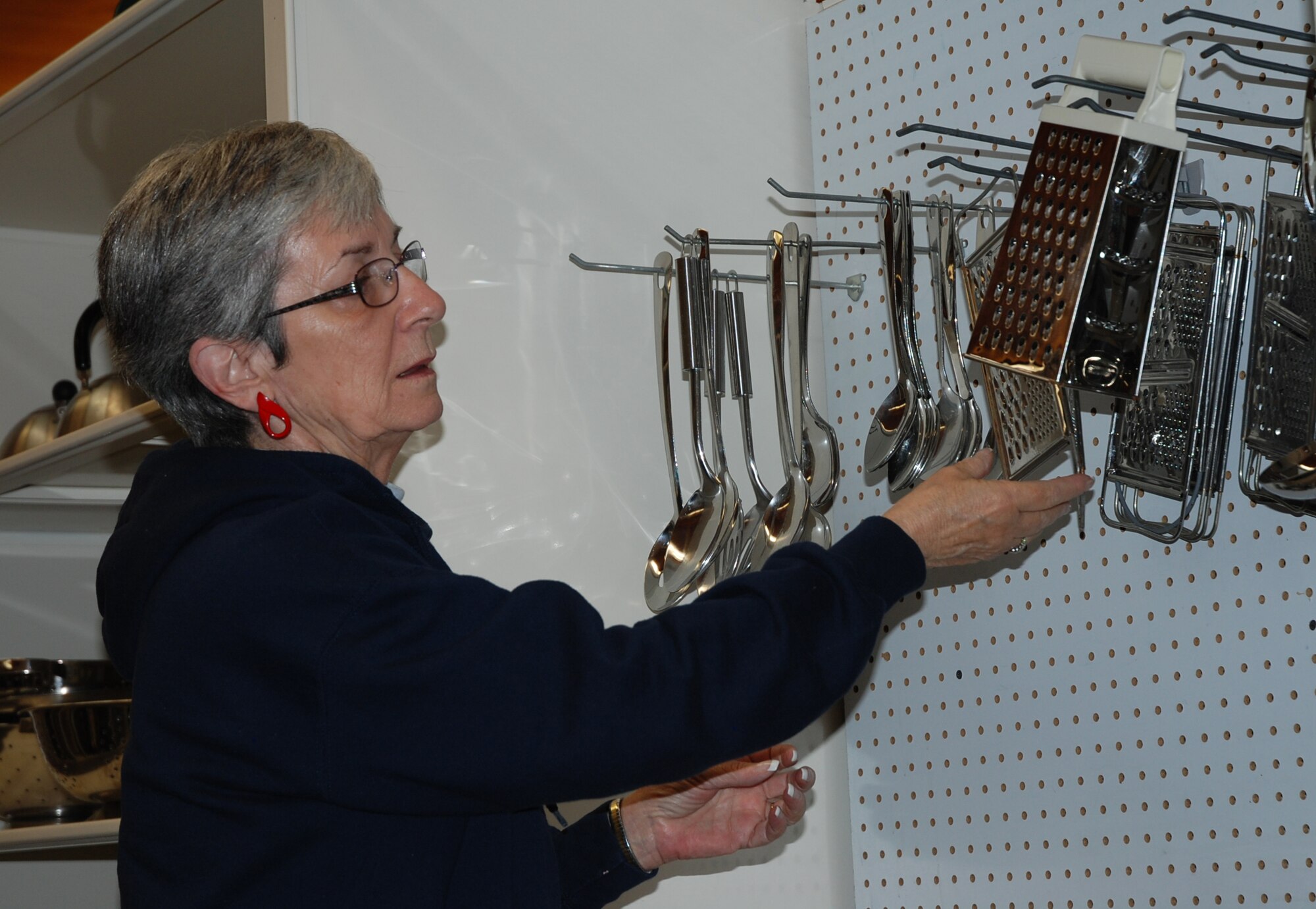 PETERSON AIR FORCE BASE, Colo. - Sharon Hodges, Loan Locker manager, rearranges some of the items available for loan at the facility Nov. 10, 2015. A wide range of items are available for loan to those needing to fill the gap during a permanent change of station and personal items are still in transit. With a copy of orders, Airmen and their families can borrow items for 30 days. Guest loans of two weeks can be made by retirees and DoD civilians. (U.S. Air Force photo by Dave Smith)