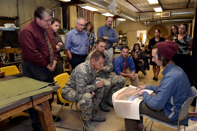 PETERSON AIR FORCE BASE, Colo. – University of Colorado Colorado Springs visual arts student Jonathan JD Sell, bottom right, shares his vision of a sculpture for the Peterson east gate marquee with Col. Reginald Ash, 21st Mission Support Group commander and architects from the 21st Civil Engineer Squadron during a presentation at UCCS, Nov. 3, 2015. Nine UCCS hopefuls submitted designs in a unique partnership between the university and the 21st Space Wing. (U.S. Air Force photo by Rob Bussard)
