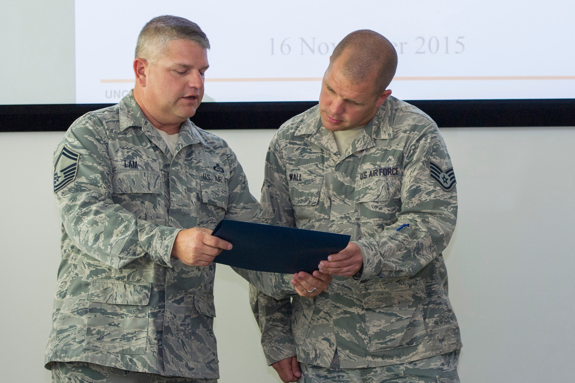 Senior Master Sgt. Gary Lam, 45th Weather Squadron superintendent and Space Coast Top-3 Association president, presents Staff Sgt. Clint Wall, 45th Launch Support Squadron unit training manager, with a superior performer award for the month of August, at Patrick Air Force Base, Fla., Nov. 16, 2015. The sergeant was recognized for exemplary duty performance, self-improvement initiatives and community involvement. Additionally, the sergeant was coined and given a one-night complementary stay at a hotel in Cocoa Beach, Fla. (U.S. Air Force photo/Matthew Jurgens/Released)
