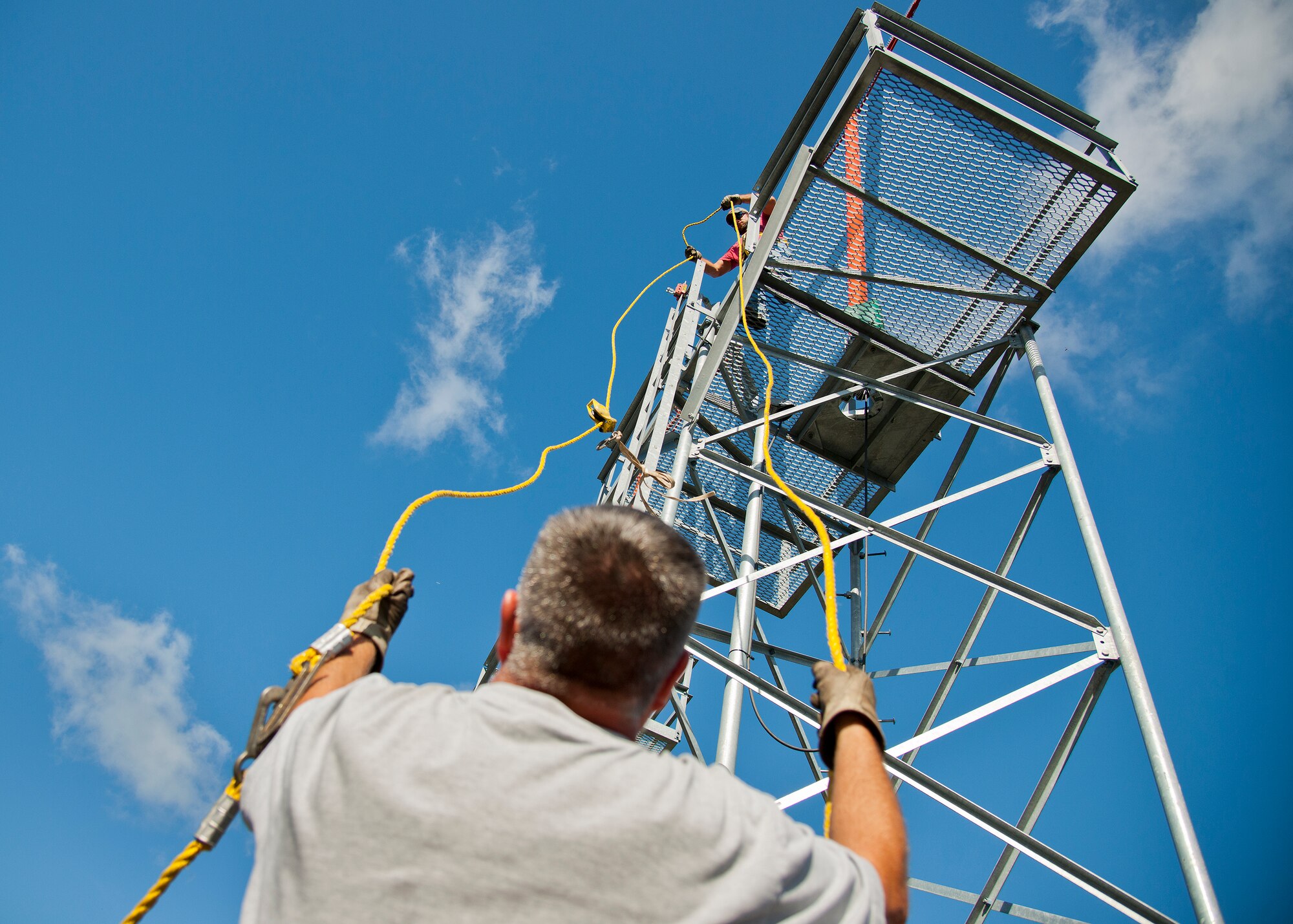 Dusty Dees and Kevin Hedman, 796th Civil Engineer Squadron, keep the pulley rope untangled after replacing a bulb on one of the of the airfield approach lighting system towers Oct. 29 at Eglin Air Force Base, Fla.  These elevated systems at Eglin and Duke Field are maintained by the 796th CES.  Eglin and Duke’s systems contain 60 elevated towers.   Each contains four 200-watt lamps.  Civil Engineer personnel change out approximately 60 of the 240 lamps used at the top of the spires every year.  (U.S. Air Force photo/Samuel King Jr.)