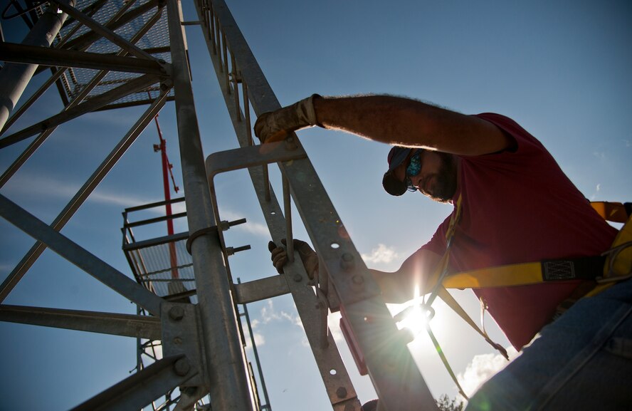 Dusty Dees, 796th Civil Engineer Squadron, begins his climb up one of the airfield approach lighting system towers to change out a lamp Oct. 29 at Eglin Air Force Base, Fla.  These elevated systems at Eglin and Duke Field are maintained by the 796th CES.  Eglin and Duke’s systems contain 60 elevated towers.   Each contains four 200-watt lamps.  Civil Engineer personnel change out approximately 60 of the 240 lamps used at the top of the spires every year.  (U.S. Air Force photo/Samuel King Jr.)