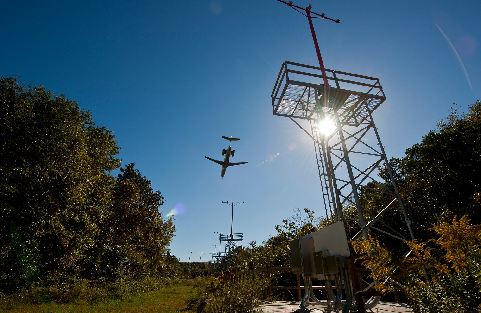 A passenger aircraft soars over the airfield approach lighting system at the end of Runway 19 at Eglin Air Force Base, Fla.  These elevated systems at Eglin and Duke Field are maintained by the 796th Civil Engineer Squadron.  Eglin and Duke’s systems contain 60 elevated towers.   Each contains four 200-watt lamps.  Civil Engineer personnel change out approximately 60 of the 240 lamps used at the top of the spires every year.  (U.S. Air Force photo/Samuel King Jr.)