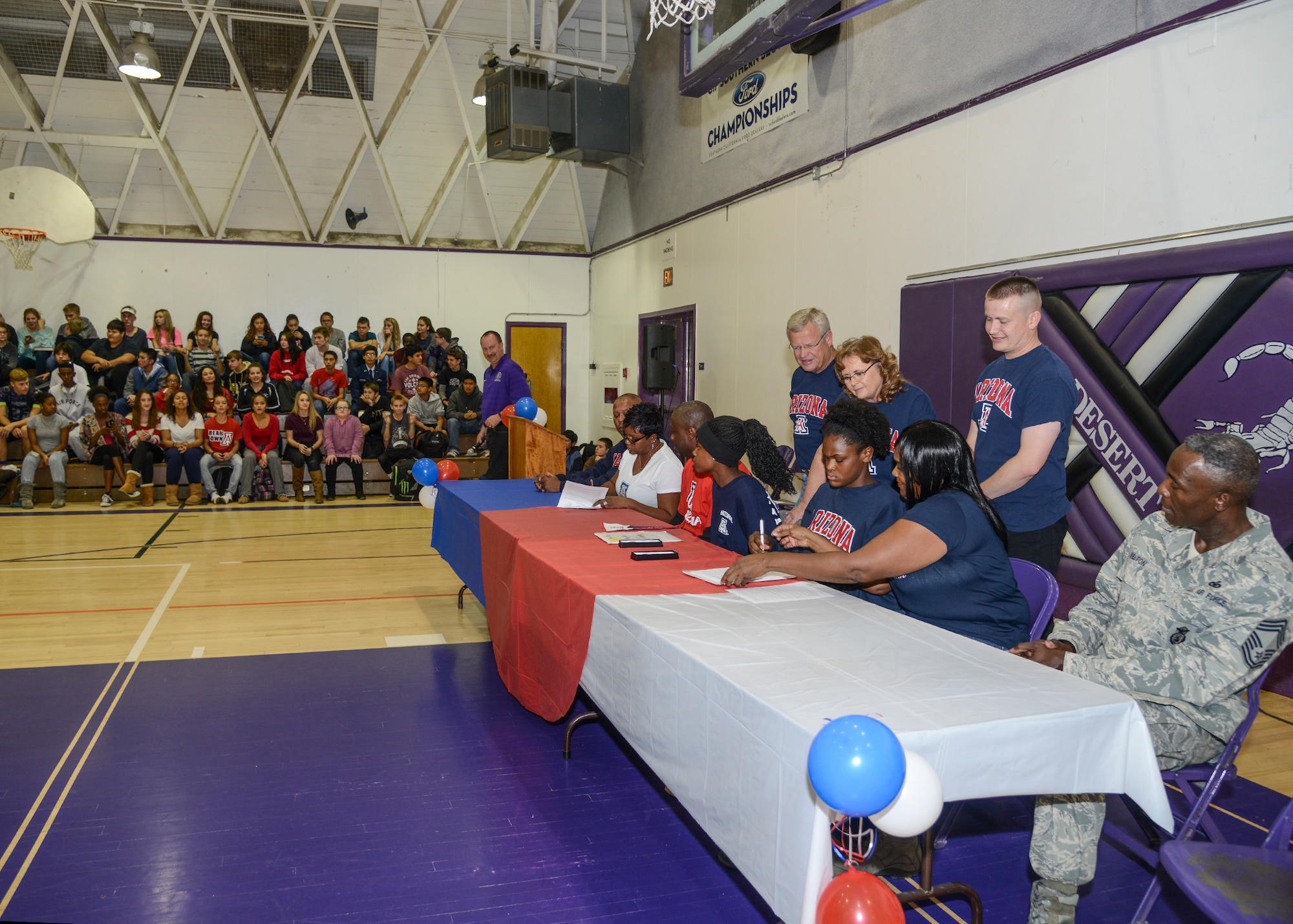 Devyn Cross, Elizabeth Shelton and their parents signed National Letters of Intent to attend the University of Arizona Nov. 13 in the Desert High School Gym while members of the student body cheered them on. (U.S. Air Force photo by Rebecca Amber)