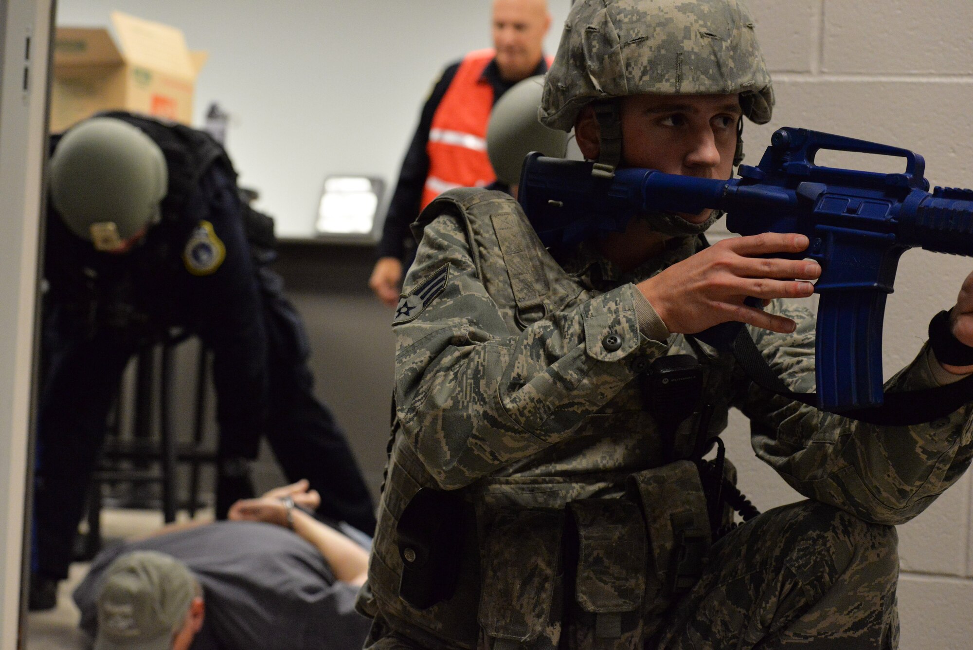 Senior Airman Brennan Sokowoski (right), 88th Security Force member, stands guard while Police Officer James Lawrence, 88th Security Forces, takes down the active shooter, played by Senior Master Sgt. Robert Welshhans Jr., 445th Airlift Wing Inspector General, during an active-shooter exercise Nov. 5 at Wright-Patterson Air Force Base. (U.S. Air Force photo / Michelle Gigante)
