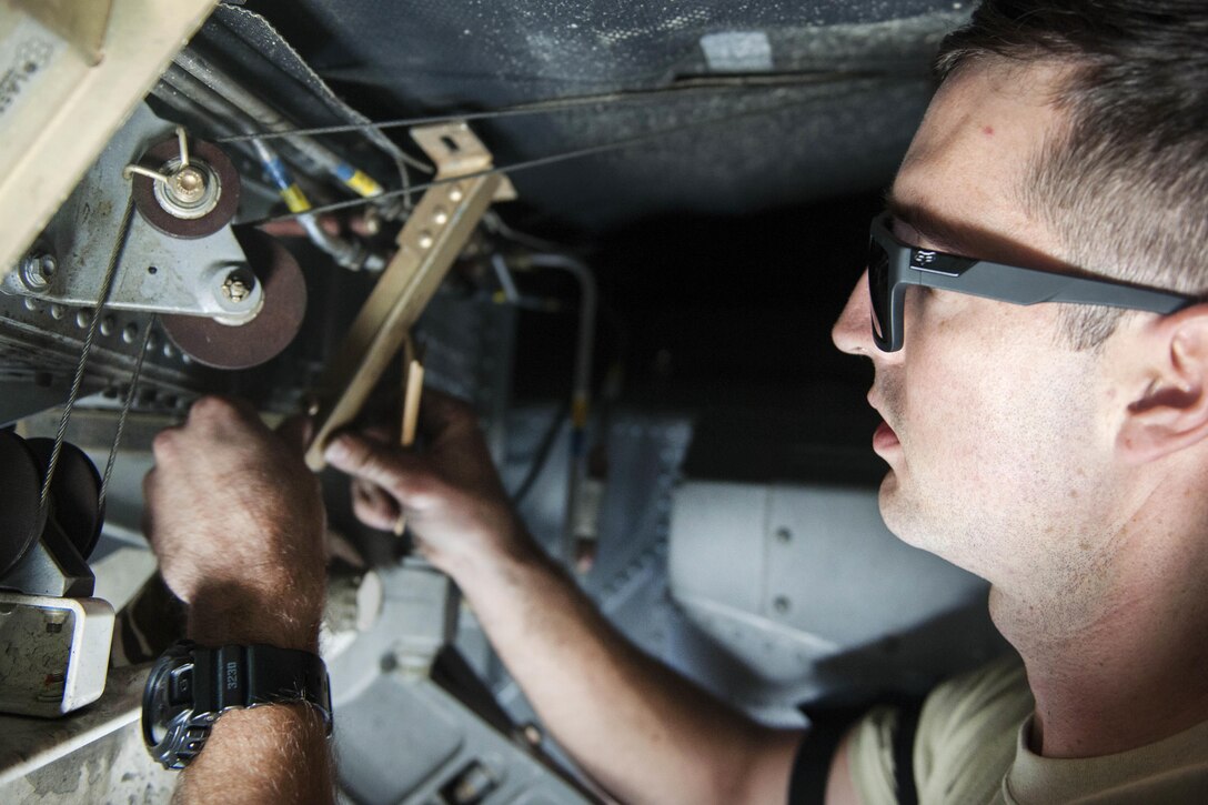 U.S. Air Force Senior Airman Zach Quinn removes a nose armor saddle bracket near the front landing gear of a C-130 Hercules aircraft on Bagram Airfield, Afghanistan, Nov. 13, 2015. Quinn is a crew chief assigned to the 455th Expeditionary Aircraft Maintenance Squadron. U.S. Air Force photo by Tech. Sgt. Robert Cloys