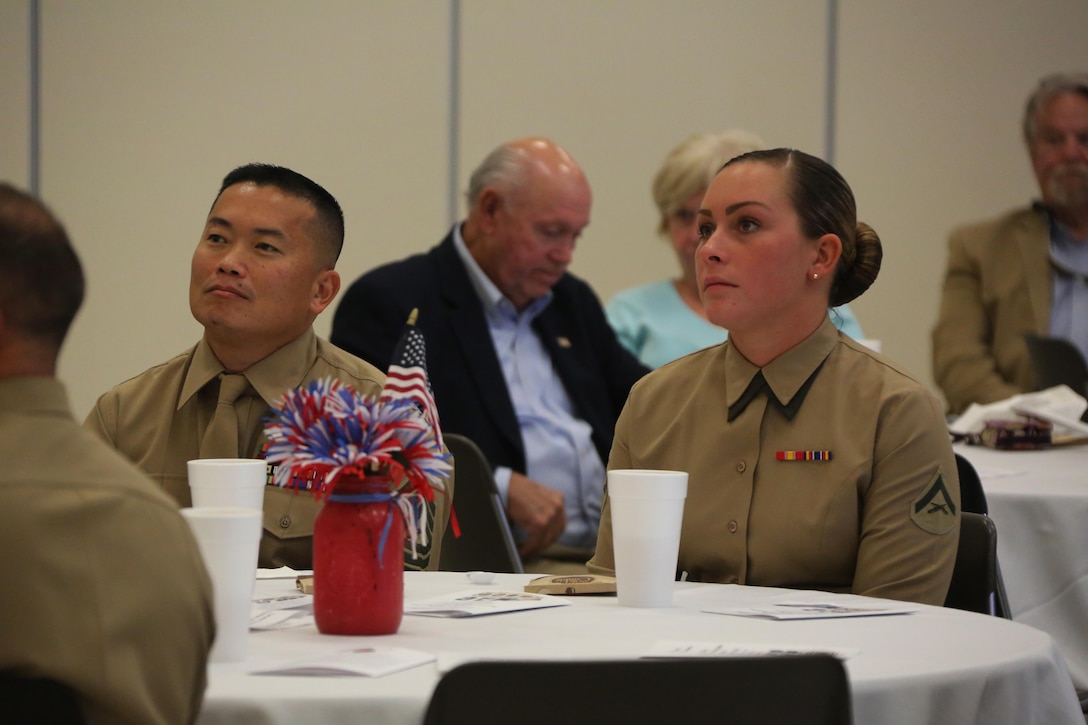 Master Sgt. Timothy Edgett, left, and Lance. Cpl. Allison App listen to guest speakers during the Carteret County Chamber of Commerce Service Person of the Quarter ceremony in Morehead City, N.C., Nov. 13, 2015. App was recognized as the Marine Corps Air Station Cherry Point Service Person of the Quarter for her dedication to both her career as a Marine and her service to the community. App has completed more than 300 volunteer hours with numerous organizations while maintaining an exemplorary role as a Marine amongst her peers. App and Edgett are both administrative specialists with Marine Wing Headquarters Squadron 2 at Marine Corps Air Station Cherry Point, N.C.(U.S.Marine Corps photo by Cpl. N.W. Huertas/ Released)