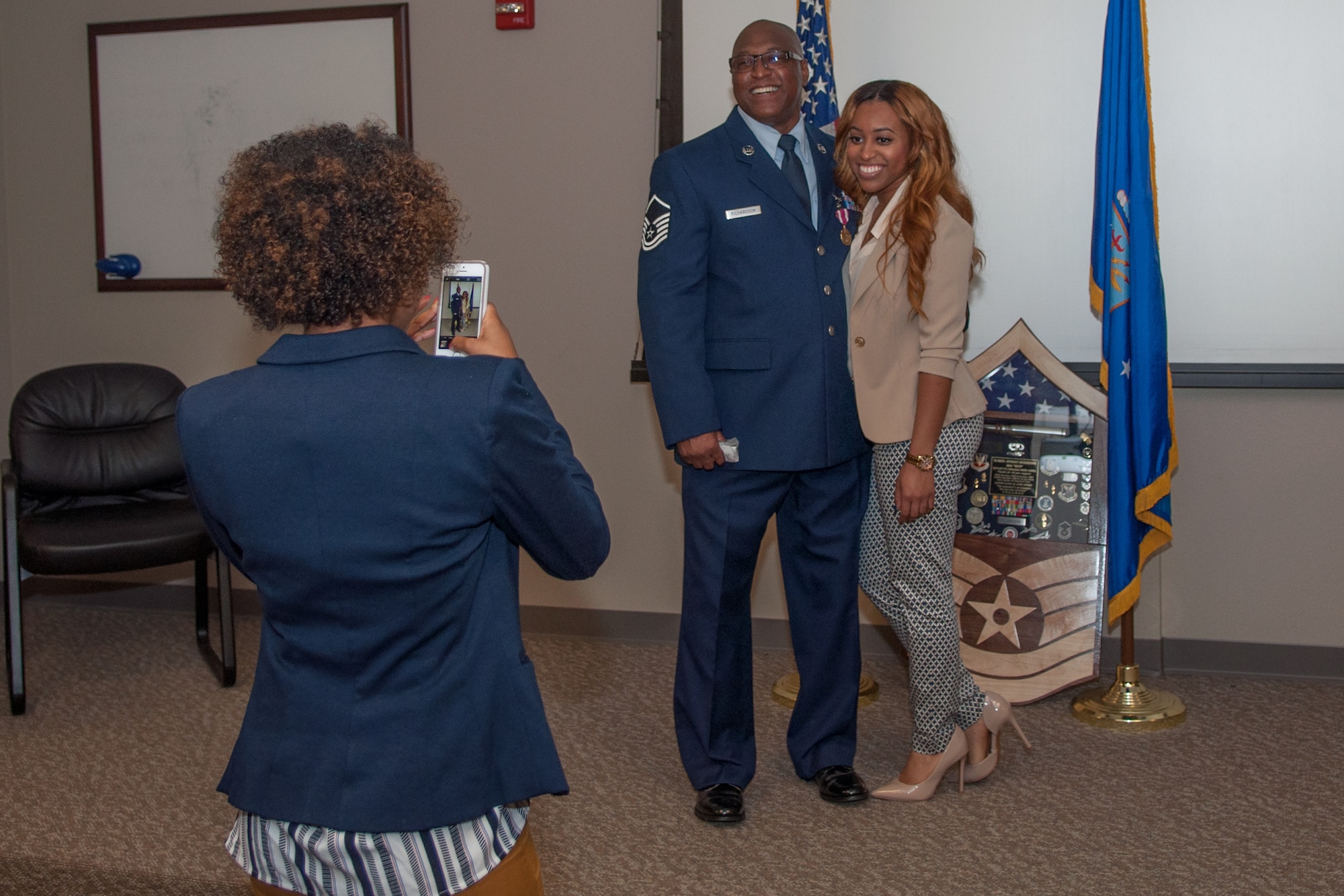 U.S. Air Force Master Sgt. Anthony Richardson stands with one of his daughters for a picture on November 7, 2015 on Barksdale Air Force Base, La. Richardson is retiring as the Noncommissioned Officer in Charge of the Munitions Flight Line Delivery Section in the 307th Maintenance Squadron and has over 32 years of military service. (U.S. Air Force photo by Master Sgt. Dachelle Melville/Released)