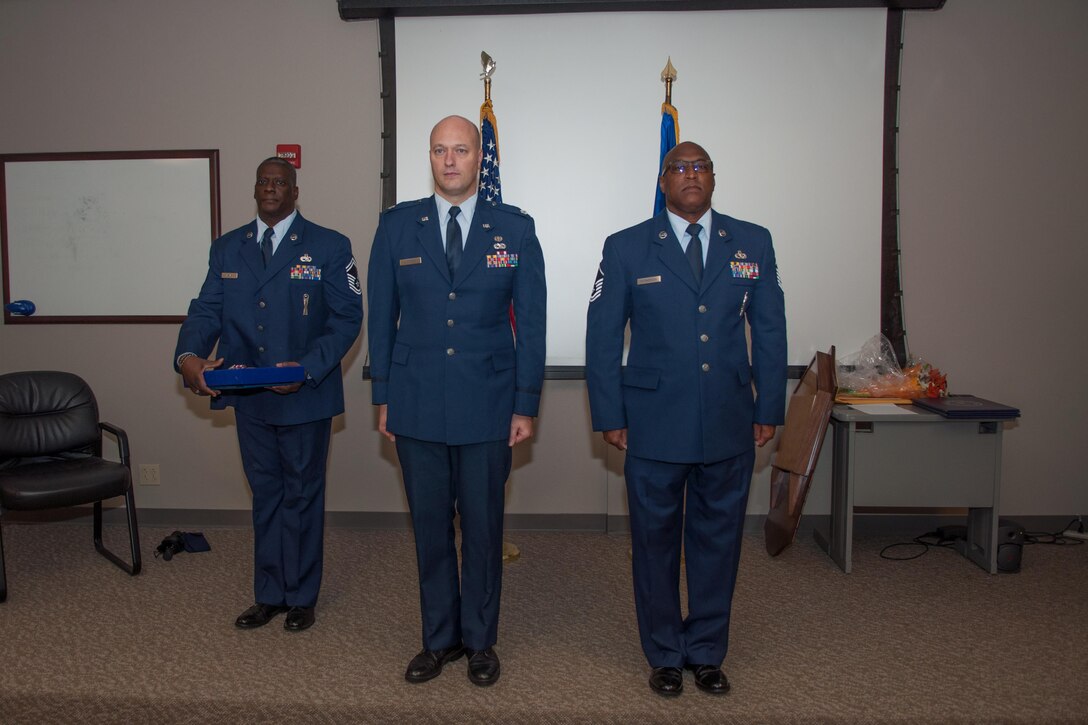 U.S. Air Force Lt. Col. Robert Luttrell III, the Deputy Staff Judge Advocate of the 307th Bomb Wing, prepares to award Master Sgt. Anthony Richardson, a Munitions Systems Craftsman, with a Meritorious Service Medal on November 7, 2015 on Barksdale Air Force Base, La. Richardson is also retiring after 32 years of service. (U.S. Air Force photo by Master Sgt. Dachelle Melville/Released)