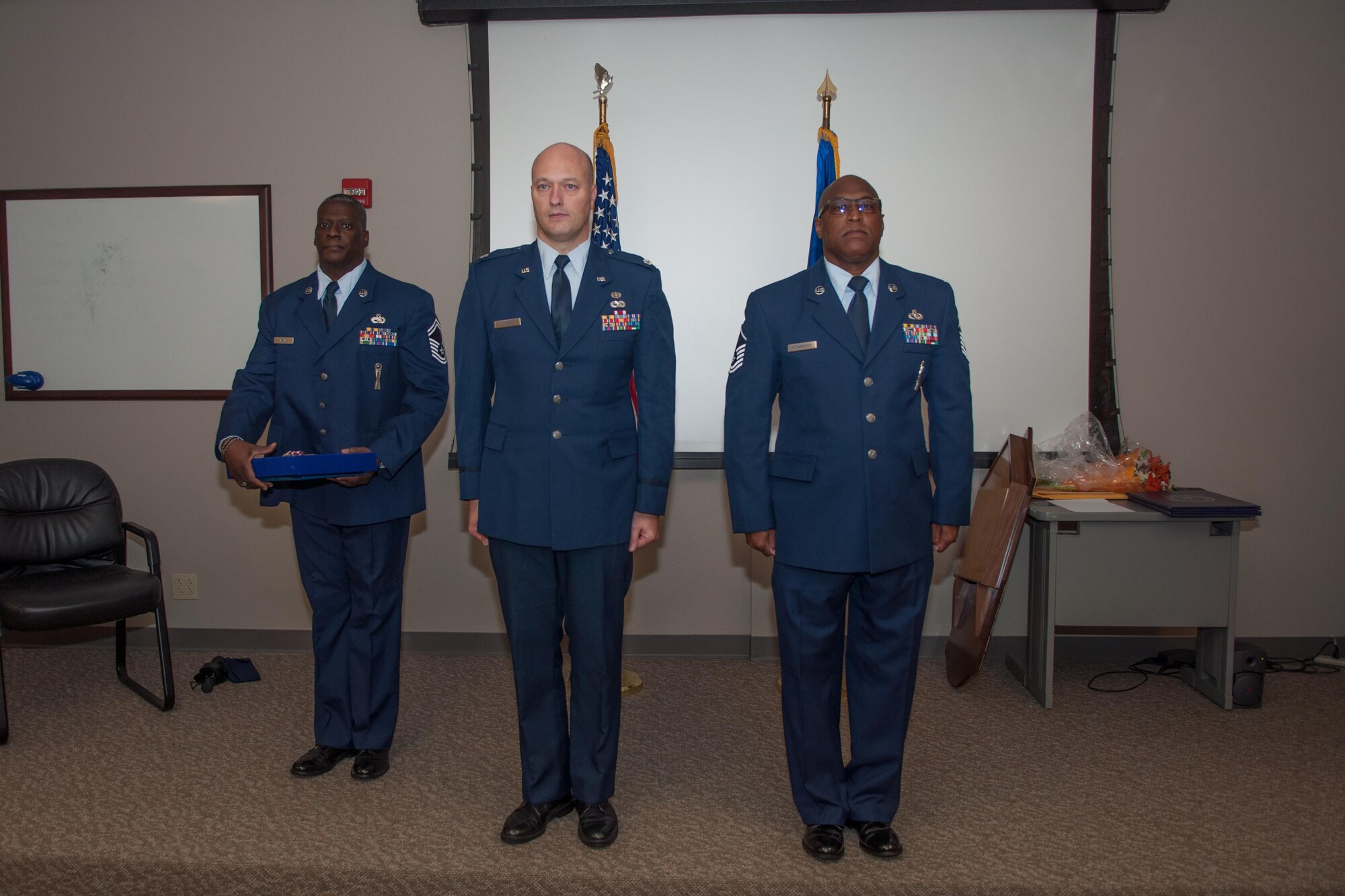 U.S. Air Force Lt. Col. Robert Luttrell III, the Deputy Staff Judge Advocate of the 307th Bomb Wing, prepares to award Master Sgt. Anthony Richardson, a Munitions Systems Craftsman, with a Meritorious Service Medal on November 7, 2015 on Barksdale Air Force Base, La. Richardson is also retiring after 32 years of service. (U.S. Air Force photo by Master Sgt. Dachelle Melville/Released)