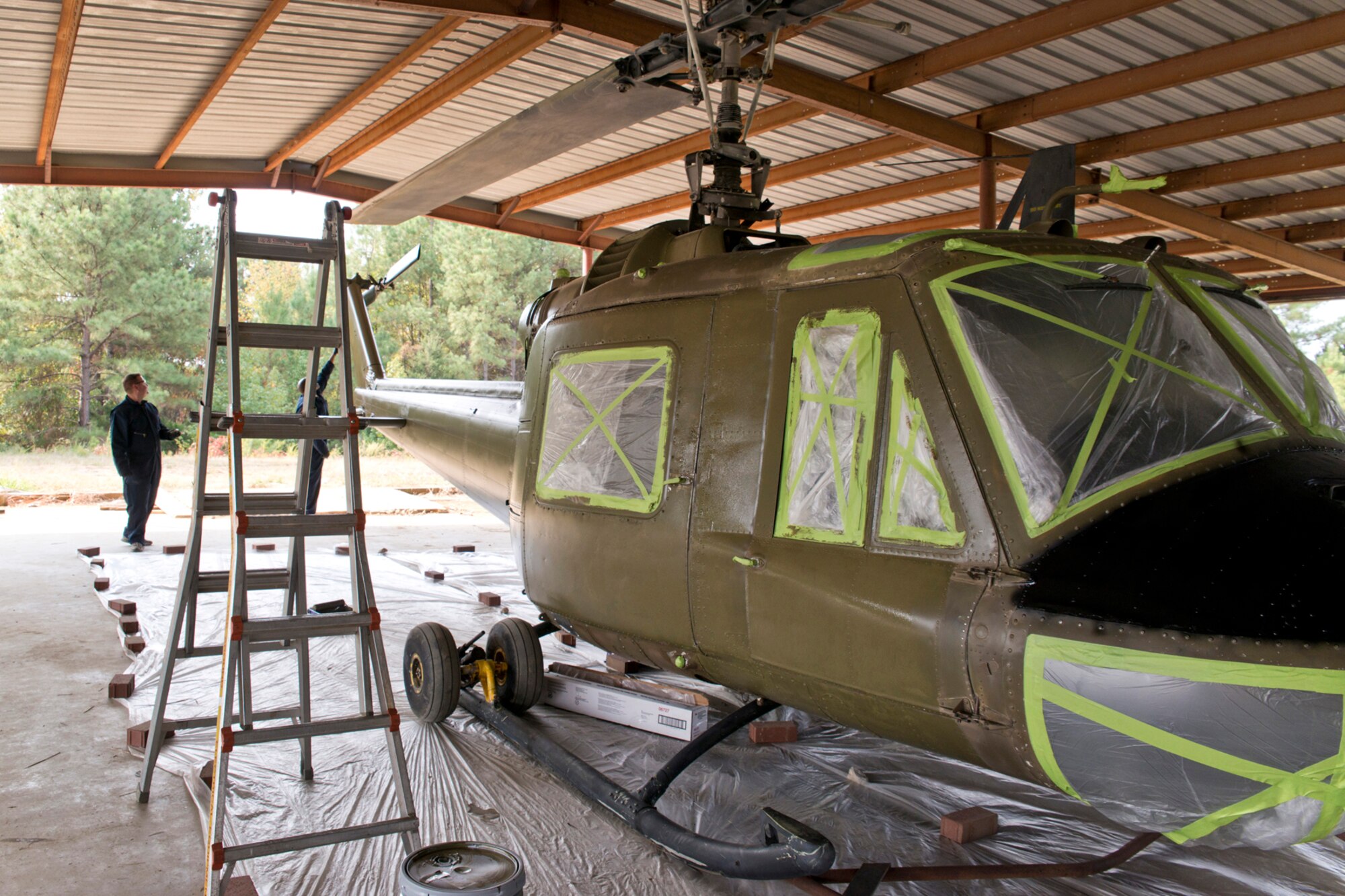 U.S. Air Force Airmen paint a Bell UH-1C Iroquois helicopter as part of a restoration project taking place at the Jacksonville Recycling Center in Jacksonville, Ark., Oct. 9, 2015. Airmen from the 913th Maintenance Squadron helped restore the Vietnam era chopper for the Jacksonville Museum of Military History, which was returned to its display on Nov. 4, 2015. (U.S. Air Force photo by Master Sgt. Jeff Walston/Released) 
