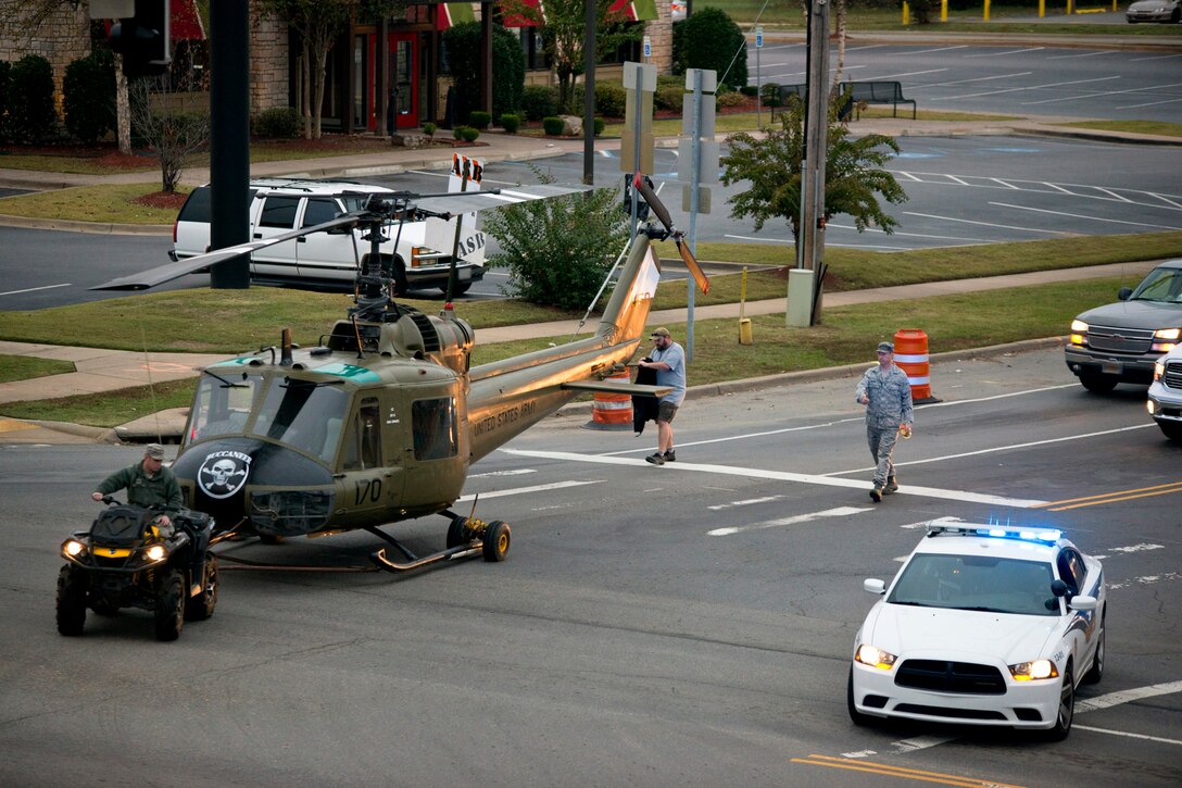 A Jacksonville City Police escort stops traffic at an intersection as a newly restored Bell UH-1C Iroquois helicopter is transported back to the Jacksonville Museum of Military History in Jacksonville, Ark., for display on Nov. 4, 2015. A group of U.S. Air Force Airmen assigned to the 913th Airlift Group at Little Rock Air Force Base, Ark., assisted in restoring the Vietnam era helicopter to its original combat color scheme and then returned it to the Jacksonville Museum of Military History for display. (U.S. Air Force photo by Master Sgt. Jeff Walston/Released)