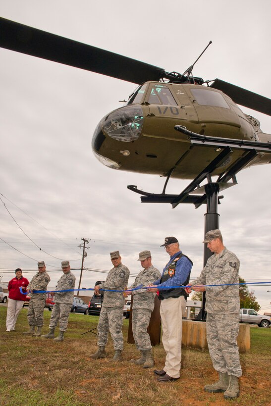 (Far Left) DannaKay Duggar, museum director, Jacksonville Museum of Military History, holds the ribbon as a group of Airmen from the 913th Maintenance Squadron and Sam Grimes (Second from Right) cuts it during the dedication ceremony for the Bell UH-1C Iroquois helicopter at the museum in Jacksonville, Ark., Nov. 7, 2015. Grimes was a crew chief on the actual helicopter on the display at the museum for nine months during the Vietnam War. (U.S. Air Force photo by Master Sgt. Jeff Walston/Released)