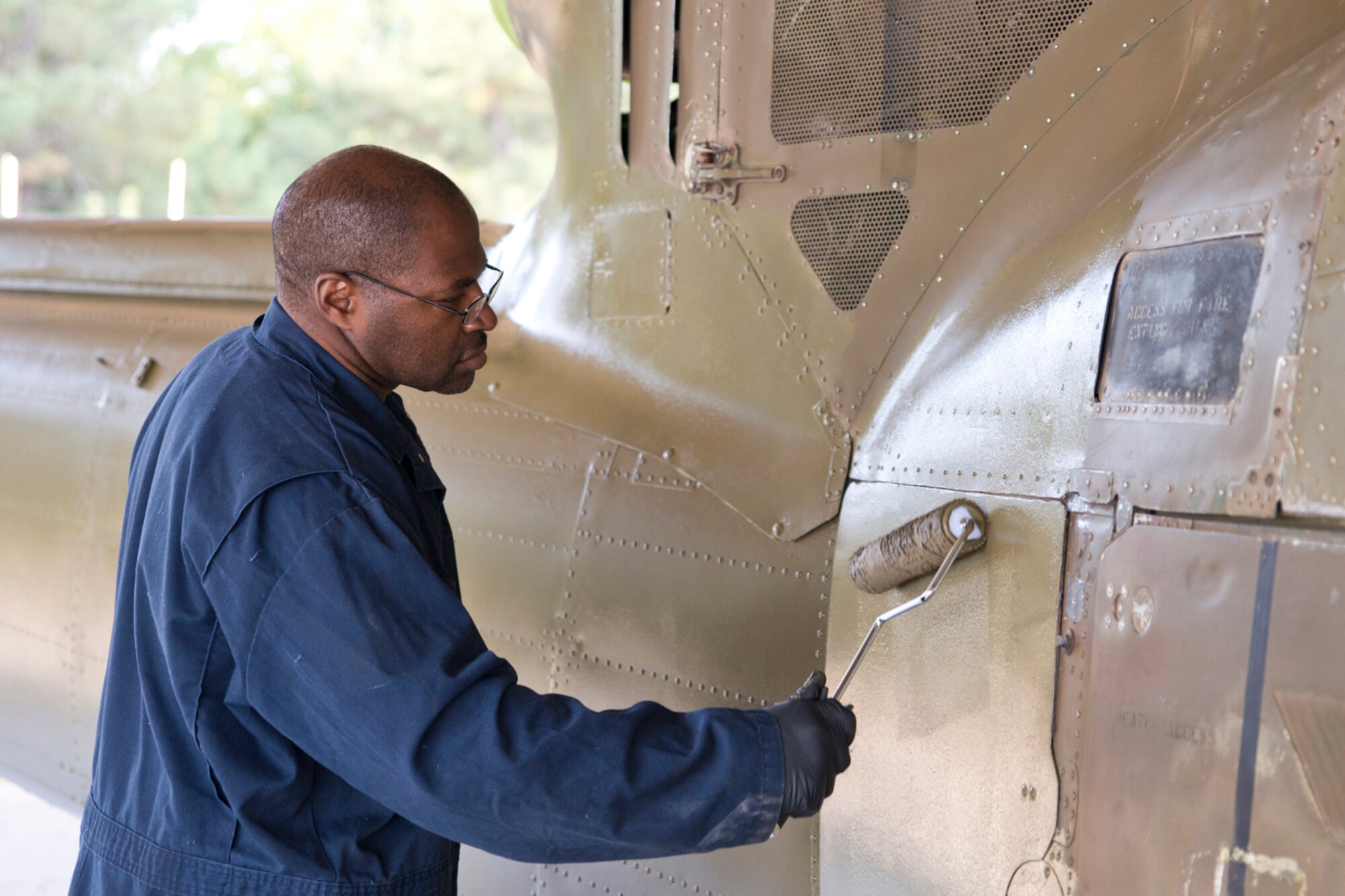 U.S. Air Force Senior Master Sgt. Jesse Brown, hydraulics supervisor, 913th Maintenance Squadron, Little Rock Air Force Base, Ark., rolls paint onto a Bell UH-1C Iroquois helicopter at the city’s recycling center just outside the Air Force base in Jacksonville, Ark., Oct. 9, 2015. Brown was part of a group of Airmen that spent the last few months restoring the Vietnam era chopper for the Jacksonville Museum of Military History. (U.S. Air Force photo by Master Sgt. Jeff Walston/Released)