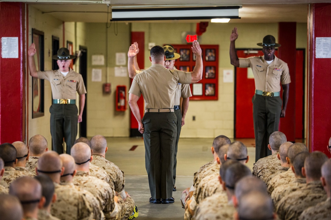 Drill instructors for Platoon 1086, Charlie Company, 1st Recruit Training Battalion, recite the Drill Instructor Pledge on July 25, 2015, before taking charge of the young men they are expected to mold into Marines on Parris Island, S.C. In the pledge, drill instructors promise to train their recruits to the best of their abilities, meaning they will not give up on the recruits even when the recruits may give up on themselves. Parris Island has been the site of Marine Corps recruit training since Nov. 1, 1915. Today, approximately 20,000 recruits come to Parris Island annually for the chance to become United States Marines by enduring 13 weeks of rigorous, transformative training. Parris Island is home to entry-level enlisted training for approximately 50 percent of males and 100 percent of females in the Marine Corps. (Photo by Sgt. Jennifer Schubert)
