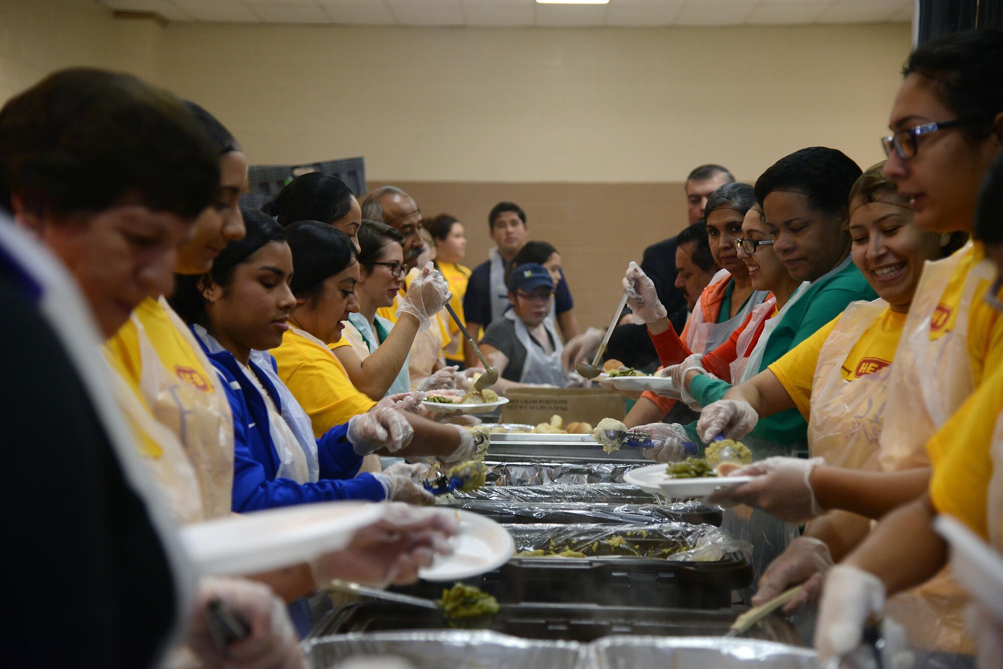 Volunteers assemble plates of food at the Del Rio Civic Center in Del Rio, Texas, Nov. 14, 2015. Volunteers at the H-E-B Feast of Sharing distributed 3,000 pounds of turkey, 2,500 pounds of cornbread dressing, 750 pumpkin pies, 380 gallons of mashed potatoes, 140 gallons of turkey gravy and 95 gallons of cranberry sauce. (U.S. Air Force photo by Airman 1st Class Brandon May)