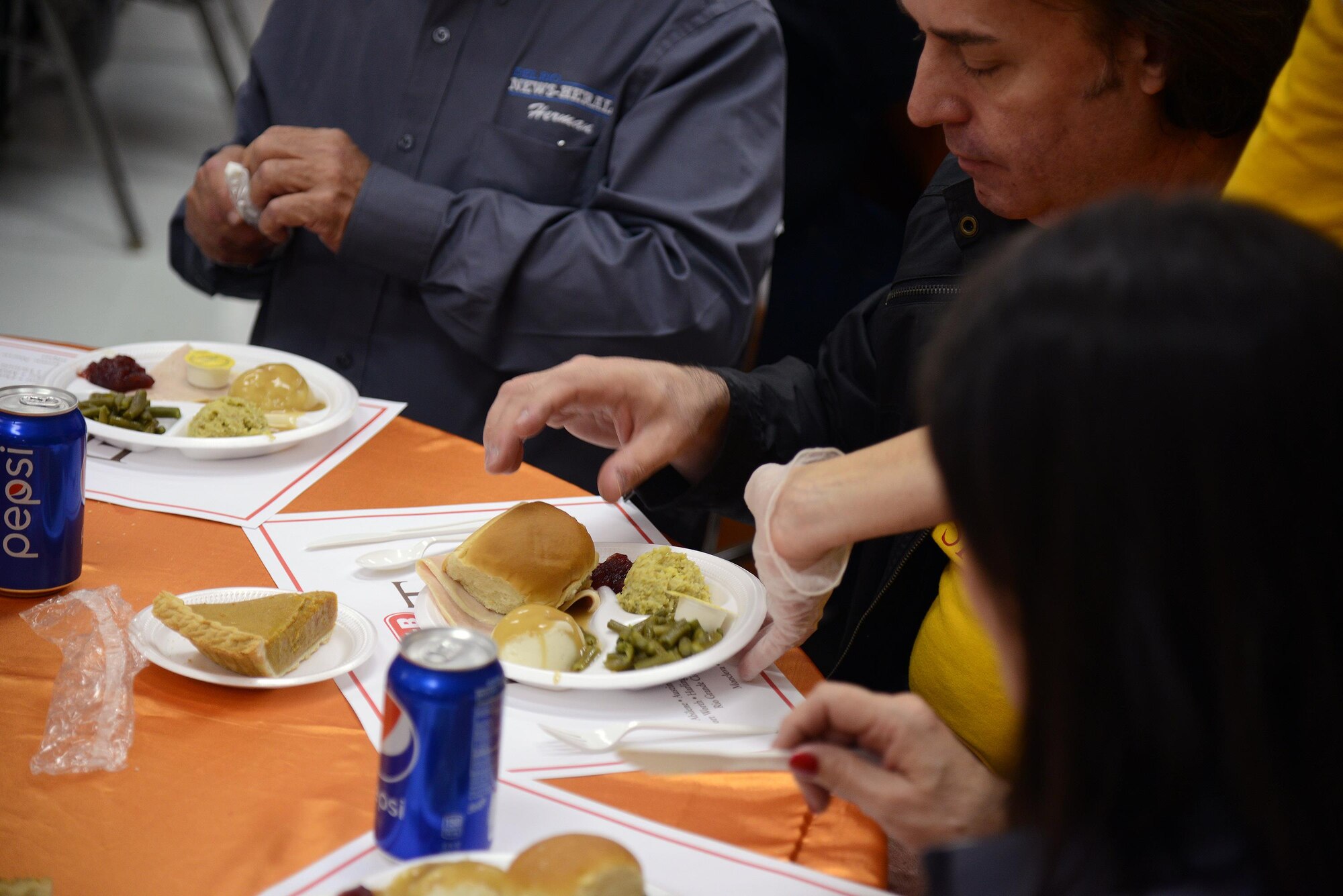 A volunteer serves food at the H-E-B Feast of Sharing at the Del Rio Civic Center in Del Rio, Texas, Nov. 14, 2015. Over 500 volunteers from Laughlin Air Force Base and the local community served more than 2,000 people. (U.S. Air Force photo by Airman 1st Class Brandon May)