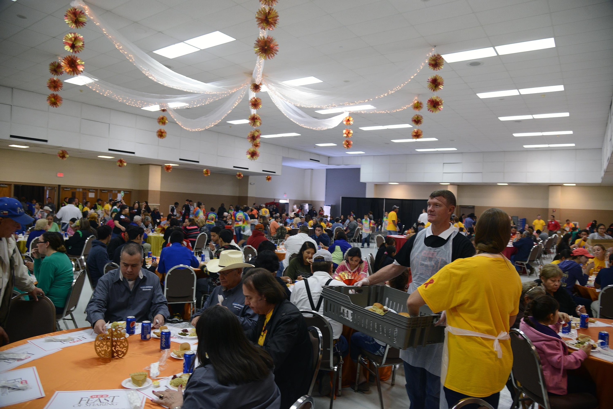 Col. Thomas Shank, 47th Flying Training Wing commander, standing, and his wife, Tonya, serve food to attendees at the Del Rio Civic Center in Del Rio, Texas, Nov. 14, 2015. This was the 23rd annual H-E-B Feast of Sharing and was free to the public. (U.S. Air Force photo by Airman 1st Class Brandon May)