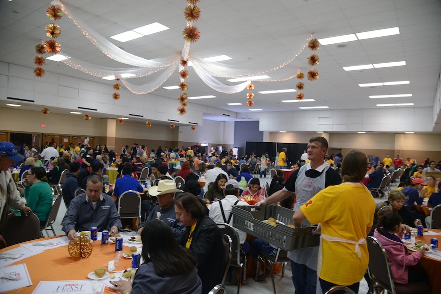 Col. Thomas Shank, 47th Flying Training Wing commander, standing, and his wife, Tonya, serve food to attendees at the Del Rio Civic Center in Del Rio, Texas, Nov. 14, 2015. This was the 23rd annual H-E-B Feast of Sharing and was free to the public. (U.S. Air Force photo by Airman 1st Class Brandon May)