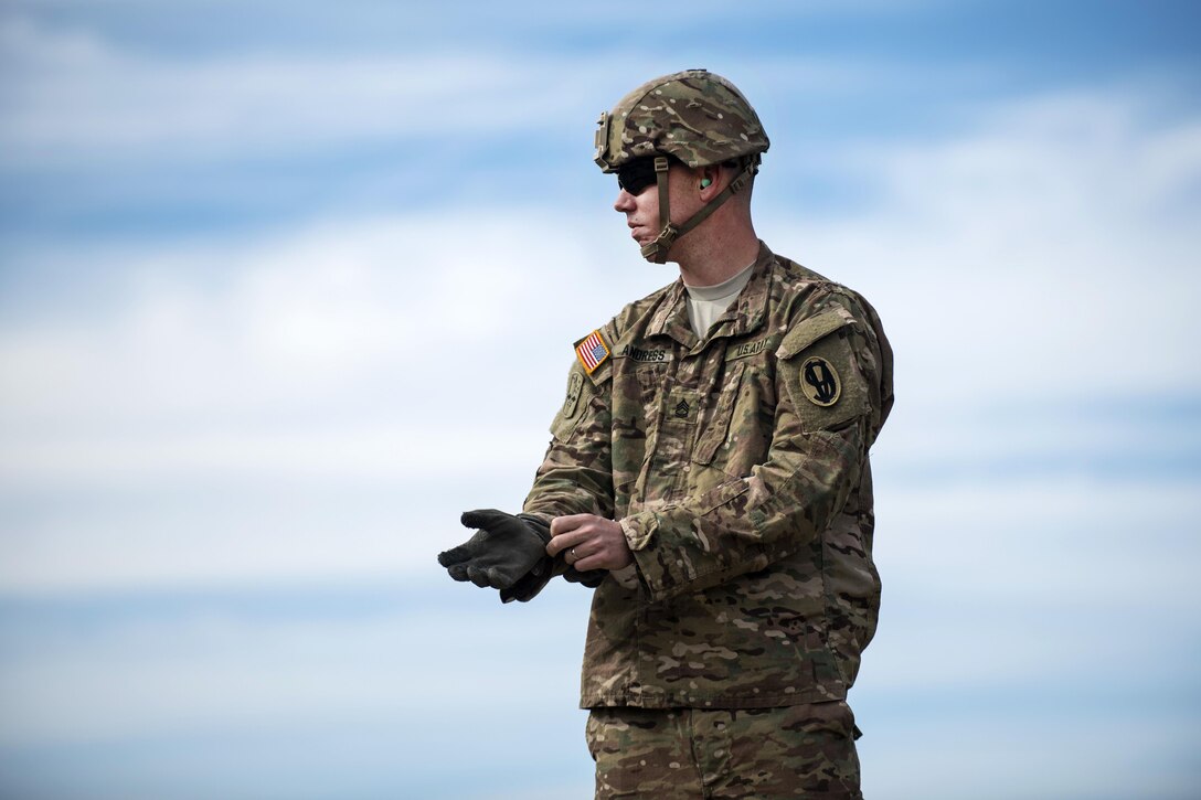 An Army sergeant puts on his gloves before assisting with safety during an M240B machine gun qualification range for Army Reserve military policemen during a multi-day training event on Camp Atterbury, Ind., Nov. 6, 2015. The sergeant is a drill instructor assigned to the 1st Battalion, 330th Infantry Regiment. U.S. Army photo by Master Sgt. Michel Sauret