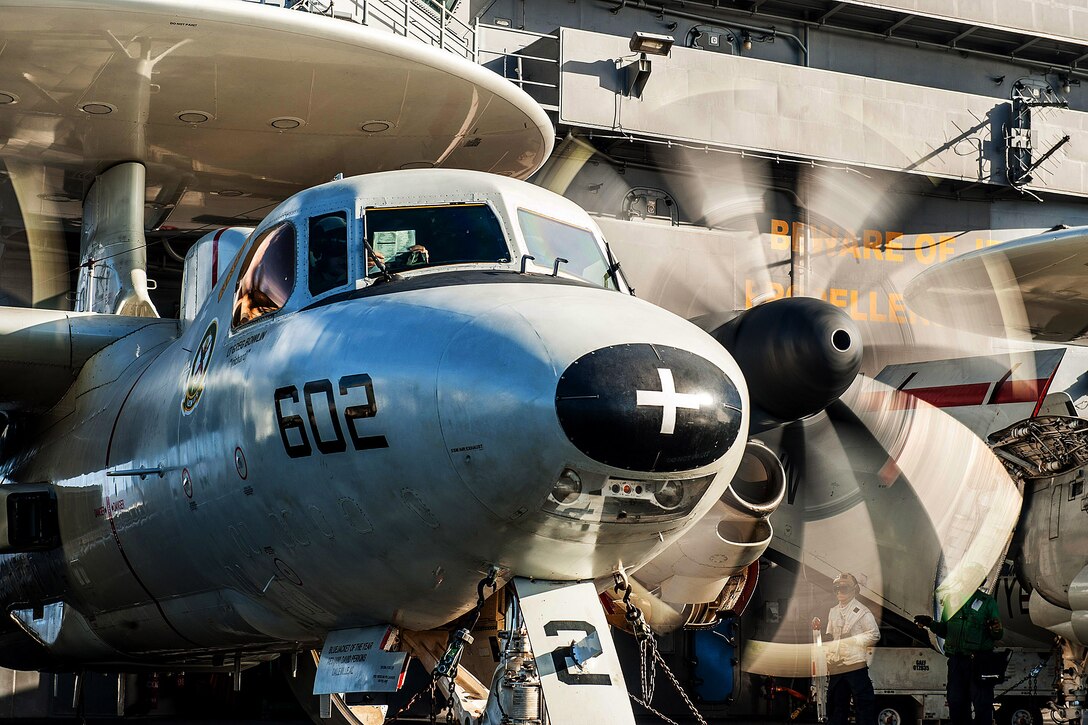 U.S. Navy Cmdr. David Waidelich performs a preflight check on an E-2C Hawkeye on the flight deck of the USS Ronald Reagan before a change of command ceremony in the Philippine Sea, Nov. 14, 2015. Waidelich assumed command of Carrier Airborne Early Warning Squadron 115 during the ceremony. U.S. Navy photo by Petty Officer 3rd Class Nathan Burke