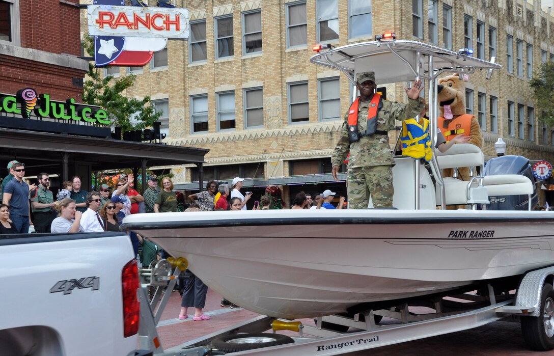 Colonel Calvin C. Hudson II, commander, Fort Worth District, U.S. Army Corps of Engineers waves to the crowd while on patrol boat during the Veteran's Day Parade at Fort Worth's Sundance Square.