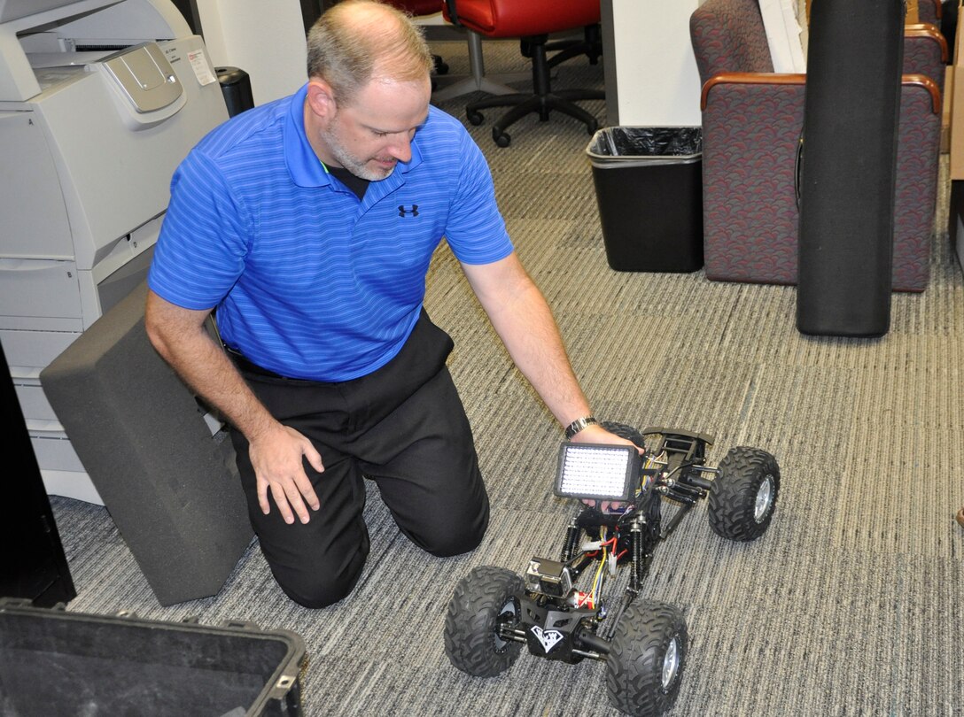 The Fort Worth District, US Army Corps of Engineers, Infrastructure Support Section chief, Matthew Milliorn, assembles the camera support package to the radio controlled camera platform during a recent test of the system
