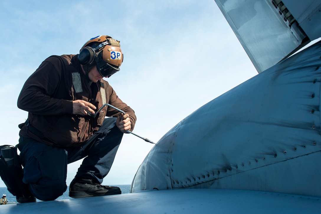U.S. Navy Airman Anthony Holliday replaces a fastener on an F/A-18E Super Hornet on the flight deck of the USS George Washington in the Atlantic Ocean, Nov. 16 2015. The George Washington is participating in the Southern Seas deployment planned by U.S. Naval Forces Southern Command. U.S. Navy photo by Petty Officer 3rd Class Jaime Marcial