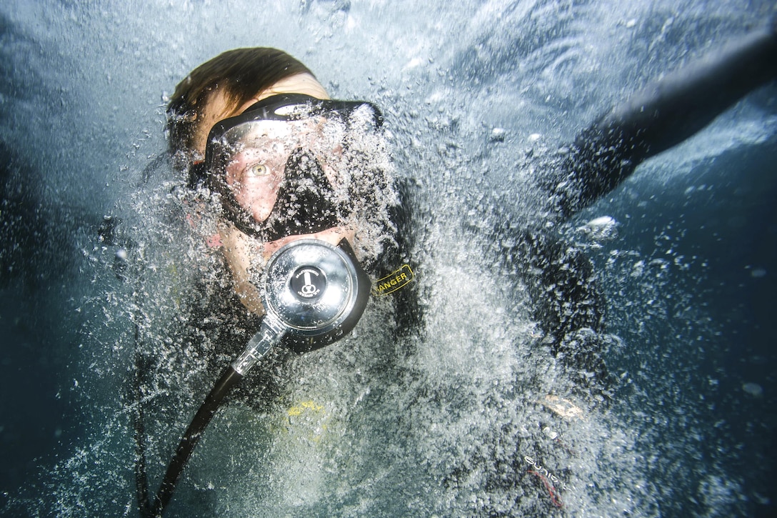 U.S. Navy Petty Officer 1st Class Charles White enters the water during underwater photo training off the coast of Guantanamo Bay, Cuba, Nov. 16, 2015. The Expeditionary Combat Camera’ underwater photo team trains annually to hone its divers specialized skill set. U.S. Navy photo by Petty Officer 1st Class Blake Midnight