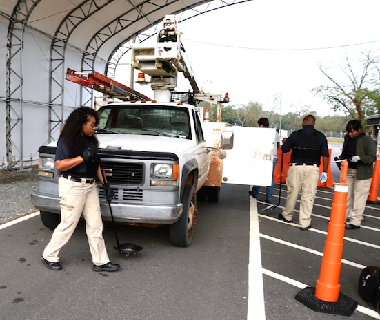 Members of the physical security team, at Marine Corps Logistics Base Albany, inspect a vehicle at the newly-constructed commercial truck entrance at Mock Road, recently. The renovated checkpoint, which was officially opened Nov. 16, was implemented as part of base safety personnel’s strategic plan to alleviate early morning traffic congestion created by commercial vehicles at the Fleming Road Gate 5.