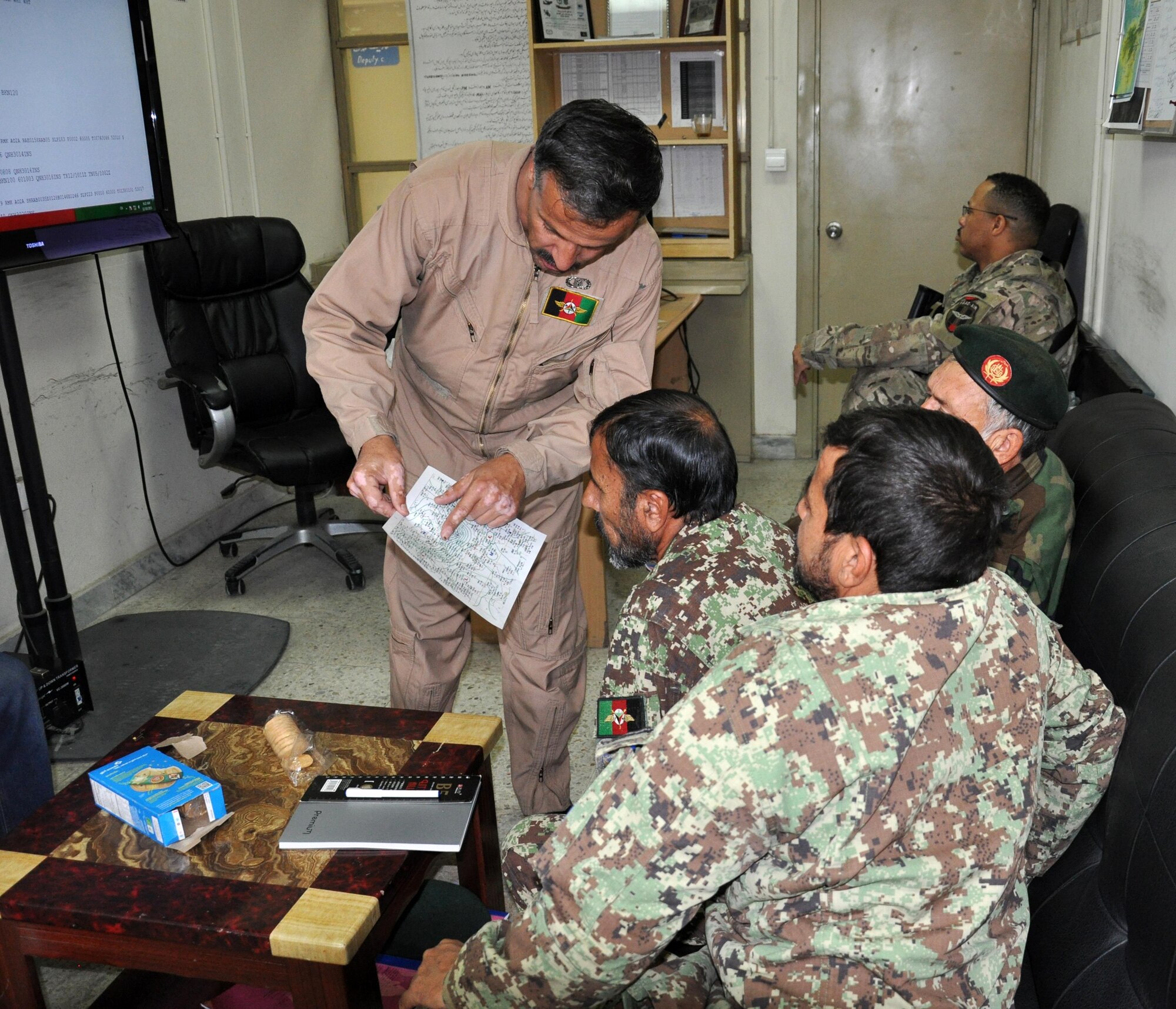 The Afghan Air Force director of meteorology teaches a course on forecasting codes to Afghan weather officers at the Kabul Air Wing, Hamid Karzai International Airport, Kabul, Afghanistan. This colonel reached a major milestone for sustainability and professionalism of the AAF operation support squadron by hosting a two-week course to bring Afghan weather officers from across Afghanistan together to hone their skills and learn new techniques. His advisor, Capt. Haley Homan, Train, Advise, Assist Command-Air (TAAC-Air), was also available to teach various subjects on weather observation and forecasting. (U.S. Air Force photo by Capt. Eydie Sakura/Released)