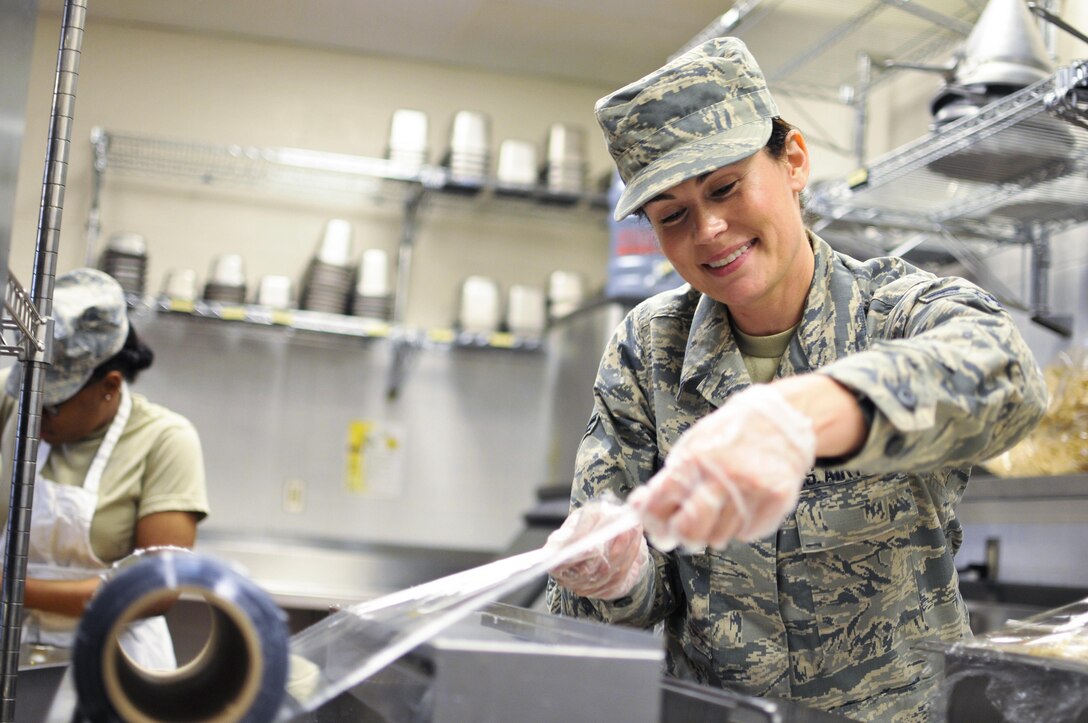 Illinois Air National Guard Airman 1st Class Tanya L. Brown, a services journeyman with the 182nd Force Support Squadron, wraps food after lunch in Peoria, Ill., May 2, 2015. Brown, a full-time beautician, farmer, student, wife and mother, enlisted in the Air National Guard at age 35. Illinois Air National Guard photo by Staff Sgt. Lealan Buehrer
