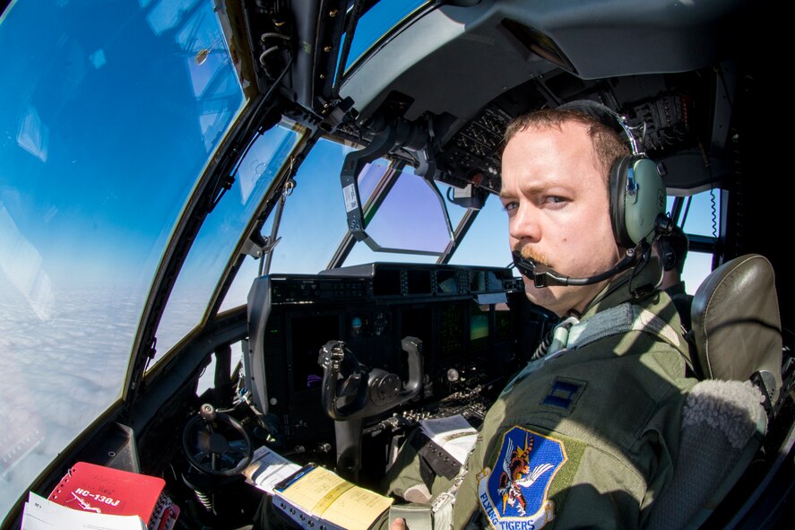 U.S. Air Force Capt. James Corless, 71st Rescue Squadron HC-130J Combat King II pilot, reaches for a visor to block the sun, Nov. 10, 2015, in the skies over Moody Air Force Base, Ga. HC-130J pilots are tasked with airdrop, helicopter air-to-air refueling, humanitarian assistance and aeromedical evacuation missions. (U.S. Air Force photo by Senior Airman Ryan Callaghan/Released)


