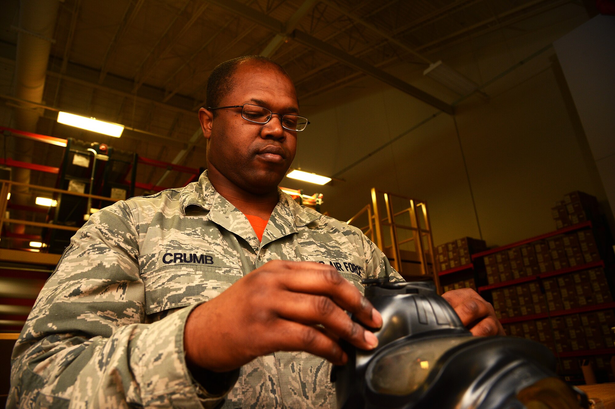 U.S. Air Force Staff Sgt. Scottie Crumb, a 20th Logistics Readiness Squadron Individual Protective Equipment supervisor, attaches a gas mask to a gas mask tester at Shaw Air Force Base, S.C., Nov. 13, 2015. As part of a new mobility storage system, Crumb, along with the rest of the IPE shop, will test and store every gas mask owned by the 20th LRS, to ensure its quality before distributing it to deploying Airmen. (U.S. Air Force photo by Senior Airman Jonathan Bass)