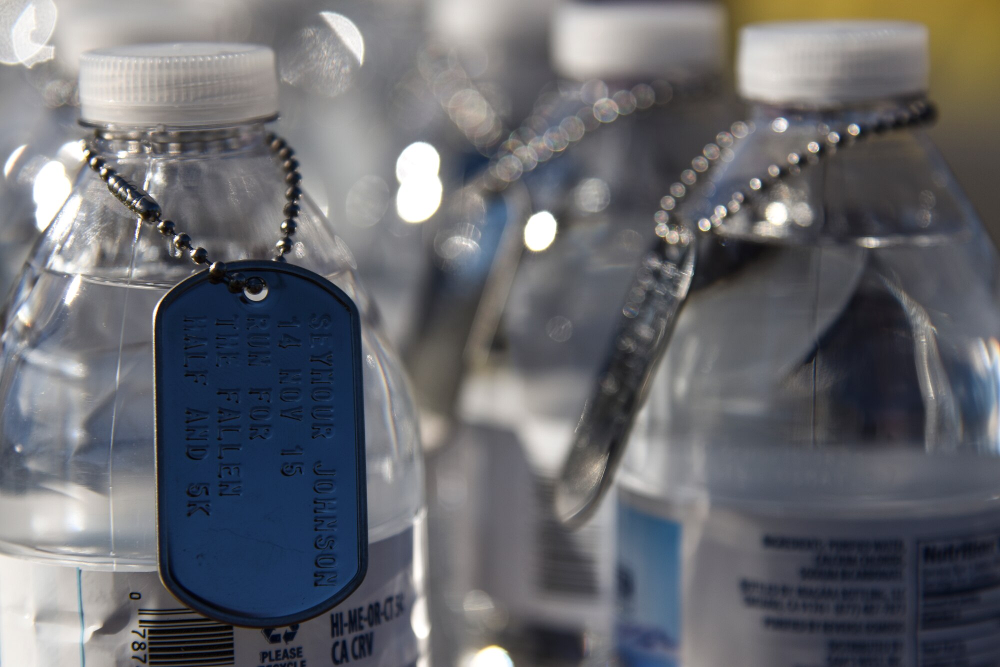 Dog tags hang from water bottles at the finish line of the Run for the Fallen Half-Marathon/5K, Nov. 14, 2015, at Seymour Johnson Air Force Base, North Carolina. The dog tags, which honored fallen service members, were presented to runners as they finished their race. (U.S. Air Force photo/Senior Airman Brittain Crolley)