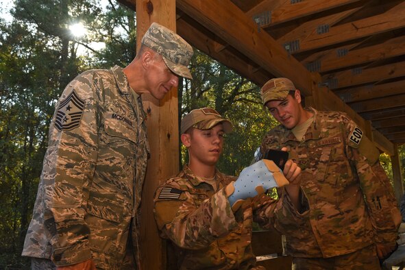Chief Master Sgt. Steve McDonald (left), Air Combat Command command chief, Airman 1st Class Adam Wasson (middle) and Senior Airman Domenic Martino, 4th Civil Engineer Squadron explosive ordnance disposal technicians, watch a video of an explosion, Nov. 13, 2015, at Seymour Johnson Air Force Base, North Carolina. McDonald detonated an explosive device at the EOD range during a unit immersion. (U.S. Air Force photo/Senior Airman Aaron J. Jenne)