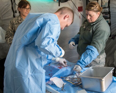 A surgical team operates on a simulated abdomen during Gunfighter Flag 16-1
at Mountain Home Air Force Base, Idaho, Nov. 5, 2015. Active duty and guard
members worked together for realistic training of deployed operations. (U.S.
Air Force photo by Airman 1st Class Jessica H. Evans)

